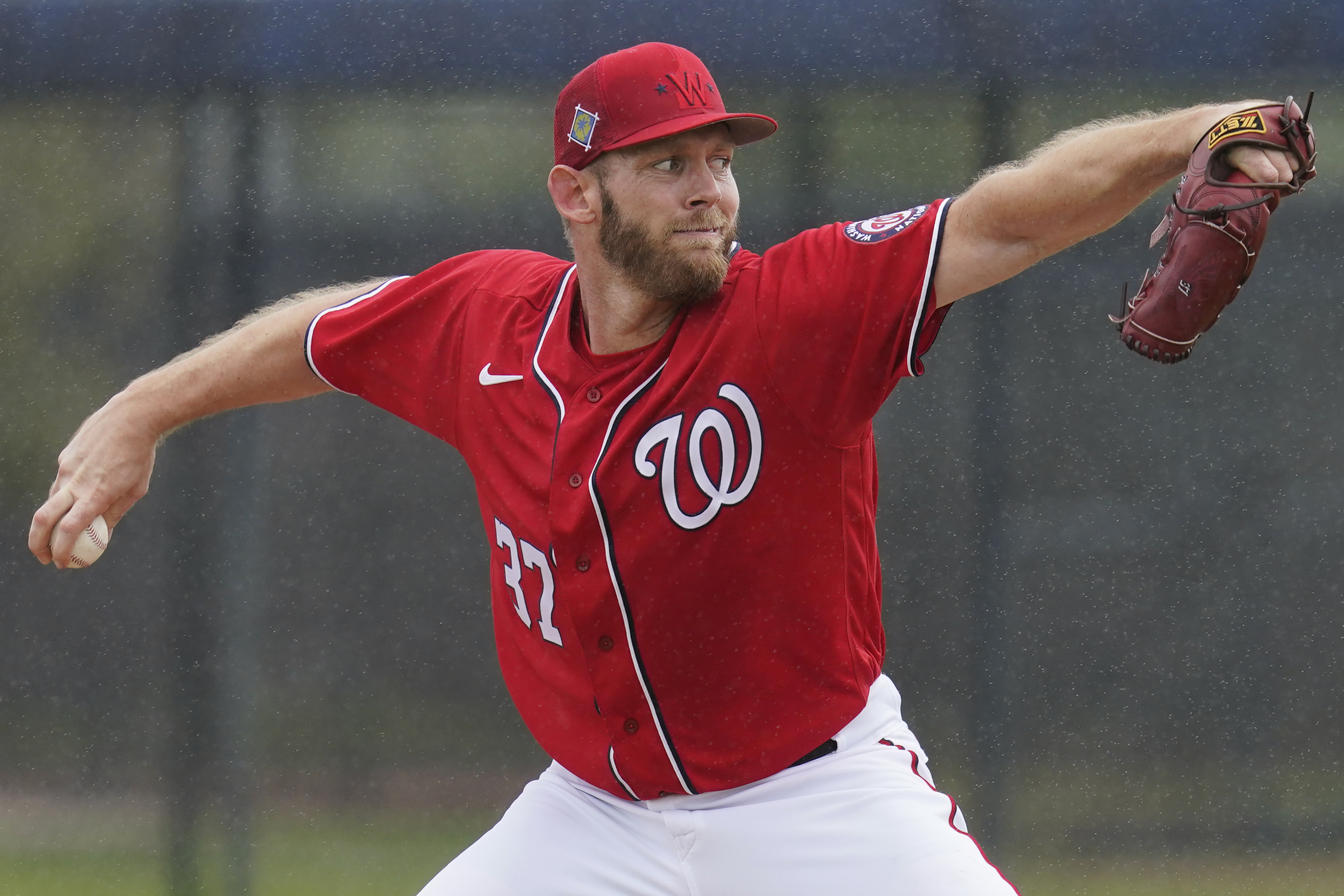 FILE - Washington Nationals pitcher Stephen Strasburg throws live batting practice in a drizzle during the team's spring training baseball workout March 15, 2022, in West Palm Beach, Fla. Strasburg is scheduled to make his season debut against the Miami Marlins on Thursday. The 33-year-old Strasburg has been sidelined for most of the past two seasons. He underwent surgery for thoracic outlet syndrome last summer and has not pitched since June 1, 2021. 