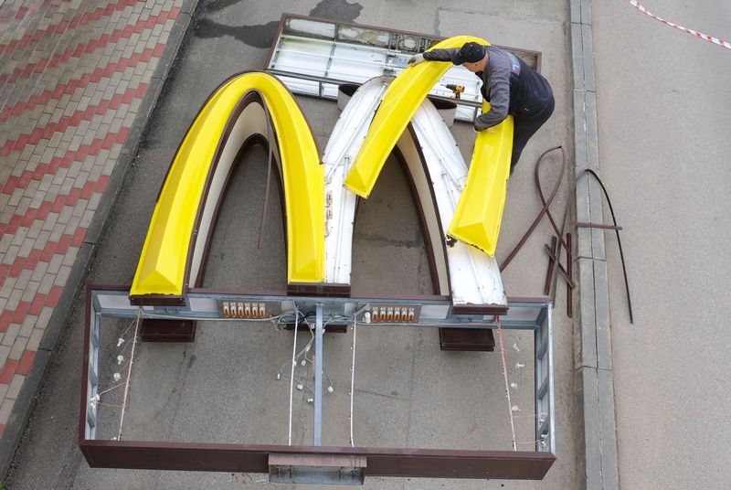 A worker dismantles the McDonald's Golden Arches while removing the logo signage from a drive-through restaurant in the town of Kingisepp in the Leningrad region, Russia, Thursday. Sunday marks a new dawn as former McDonald's restaurants in Russia reopen under new branding and ownership.