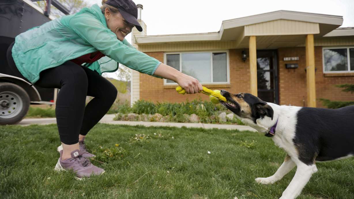 Lara Gale plays with her dog, Harvey, in front of her house in Ogden on Thursday, May 12, 2022.