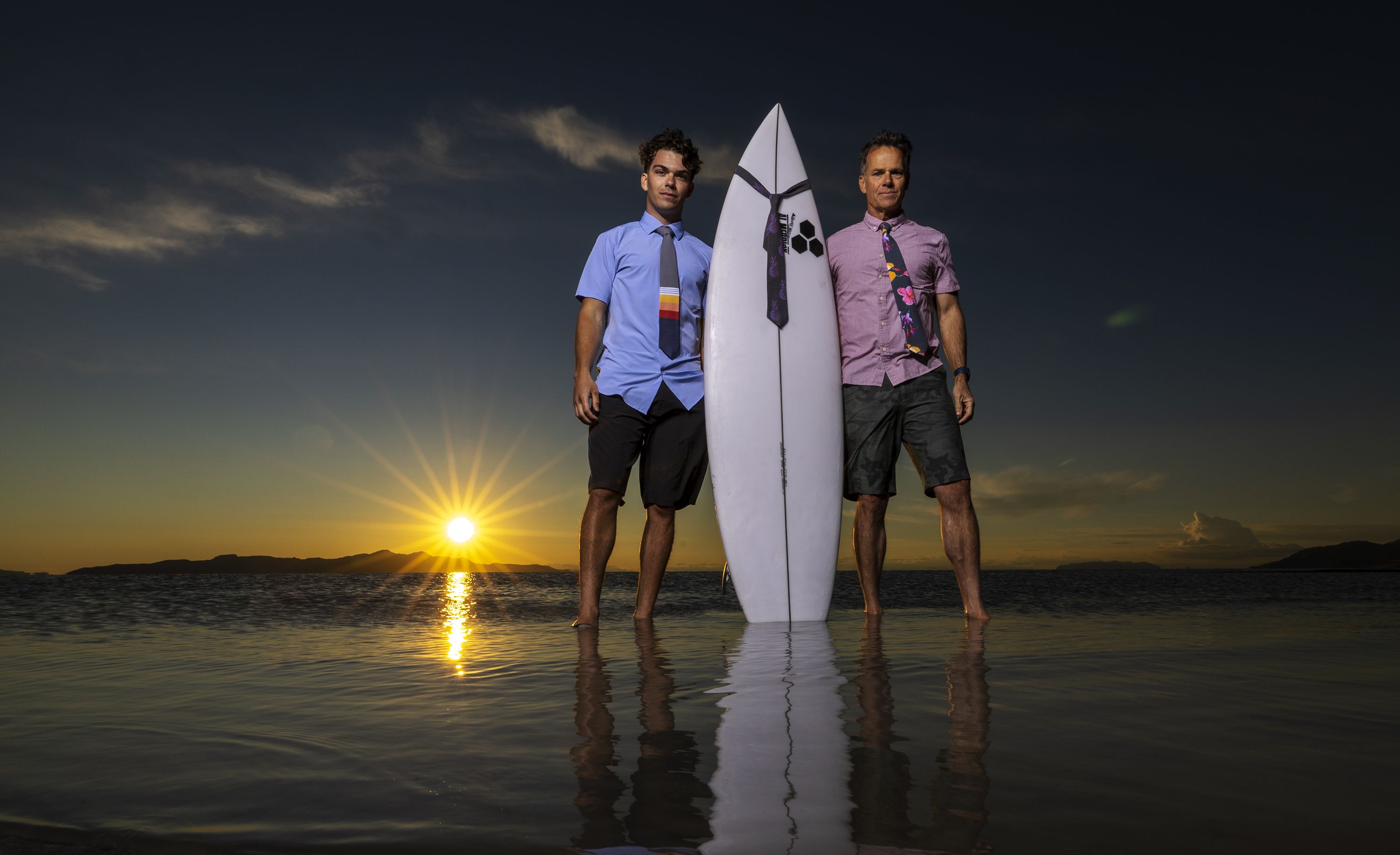 Zeke Greer and his father, Gregg, pose with some of their ties and a surfboard at the Great Salt Lake near Salt Lake City on May 31. The ties are made of the quick-drying material used in surfer’s board shorts and are sold online, in surf shops and other retail outlets like Modern Missionary in Orem.