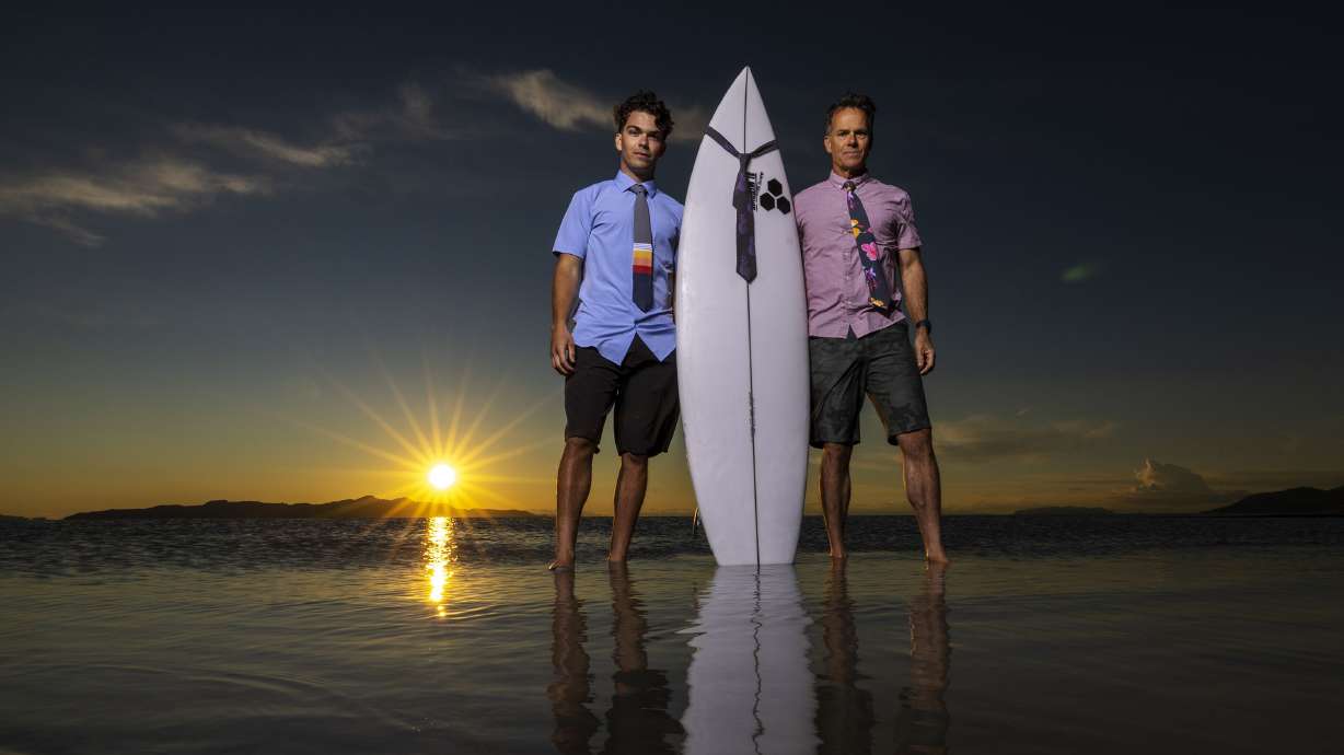 Zeke Greer and his father, Gregg, pose with some of their ties and a surfboard at the Great Salt Lake near Salt Lake City on May 31. The ties are made of the quick-drying material used in surfer’s board shorts and are sold online, in surf shops and other retail outlets like Modern Missionary in Orem.
