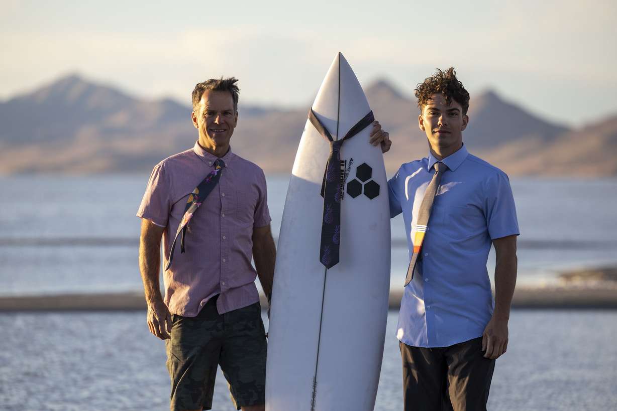 Gregg Greer and his son, Zeke, pose with some of their ties and a surfboard at the Great Salt Lake near Salt Lake City on May 31. The ties are made of the quick-drying material used in surfer’s board shorts and are sold online, in surf shops and other retail outlets like Modern Missionary in Orem.