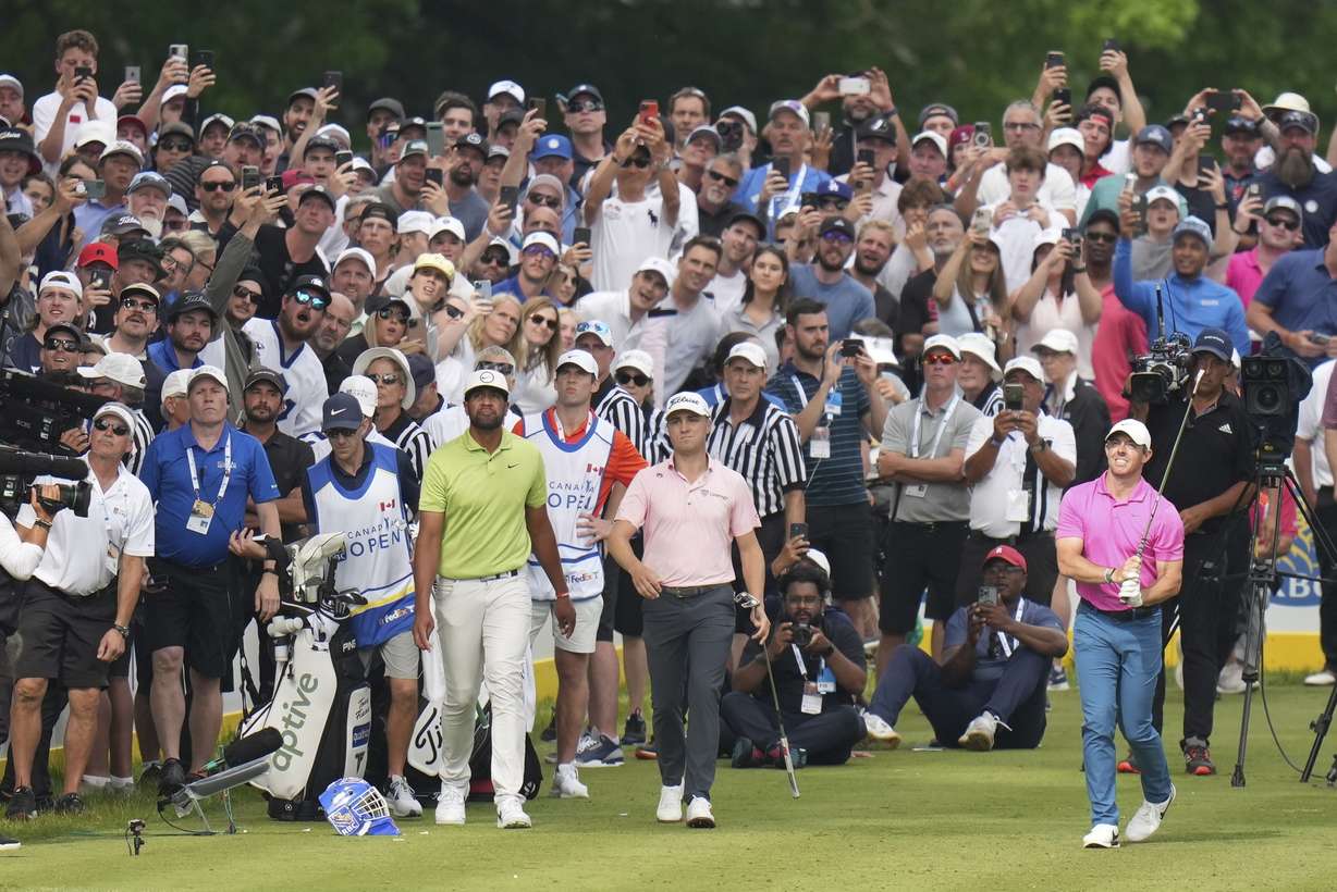 Rory McIlroy, front right, tees off on the 16th hole as Justin Thomas, center, and Tony Finau, center left, look on during the final round of the Canadian Open golf tournament in Toronto, Sunday, June 12, 2022.