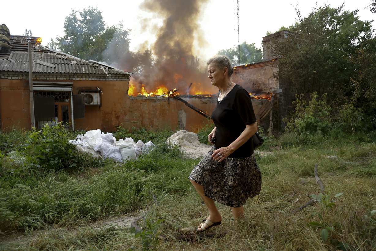 A woman runs from a house that's on fire after shelling in Donetsk, on the territory which is under the Government of the Donetsk People's Republic control, eastern Ukraine, June 3.