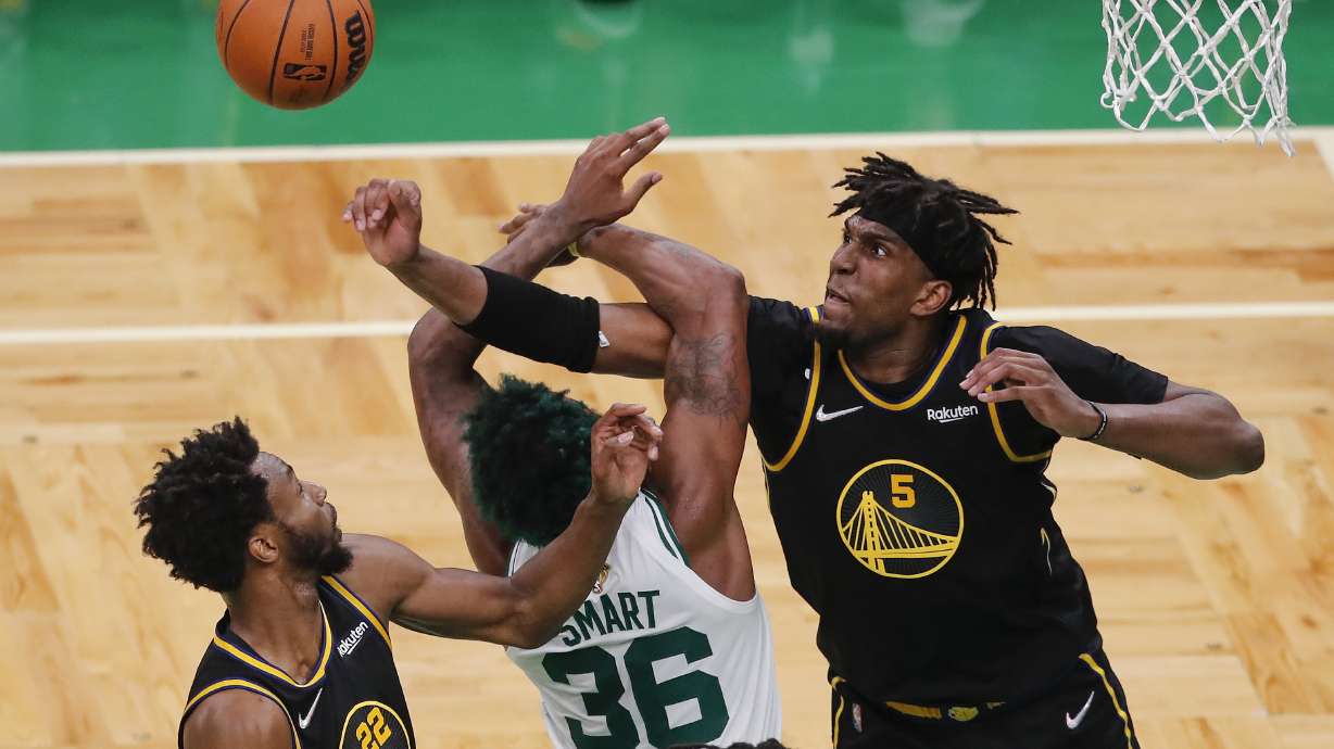 Golden State Warriors center Kevon Looney (5) and forward Andrew Wiggins (22) battle for a rebound against Boston Celtics guard Marcus Smart (36) during the fourth quarter of Game 4 of basketball's NBA Finals, Friday, June 10, 2022, in Boston.