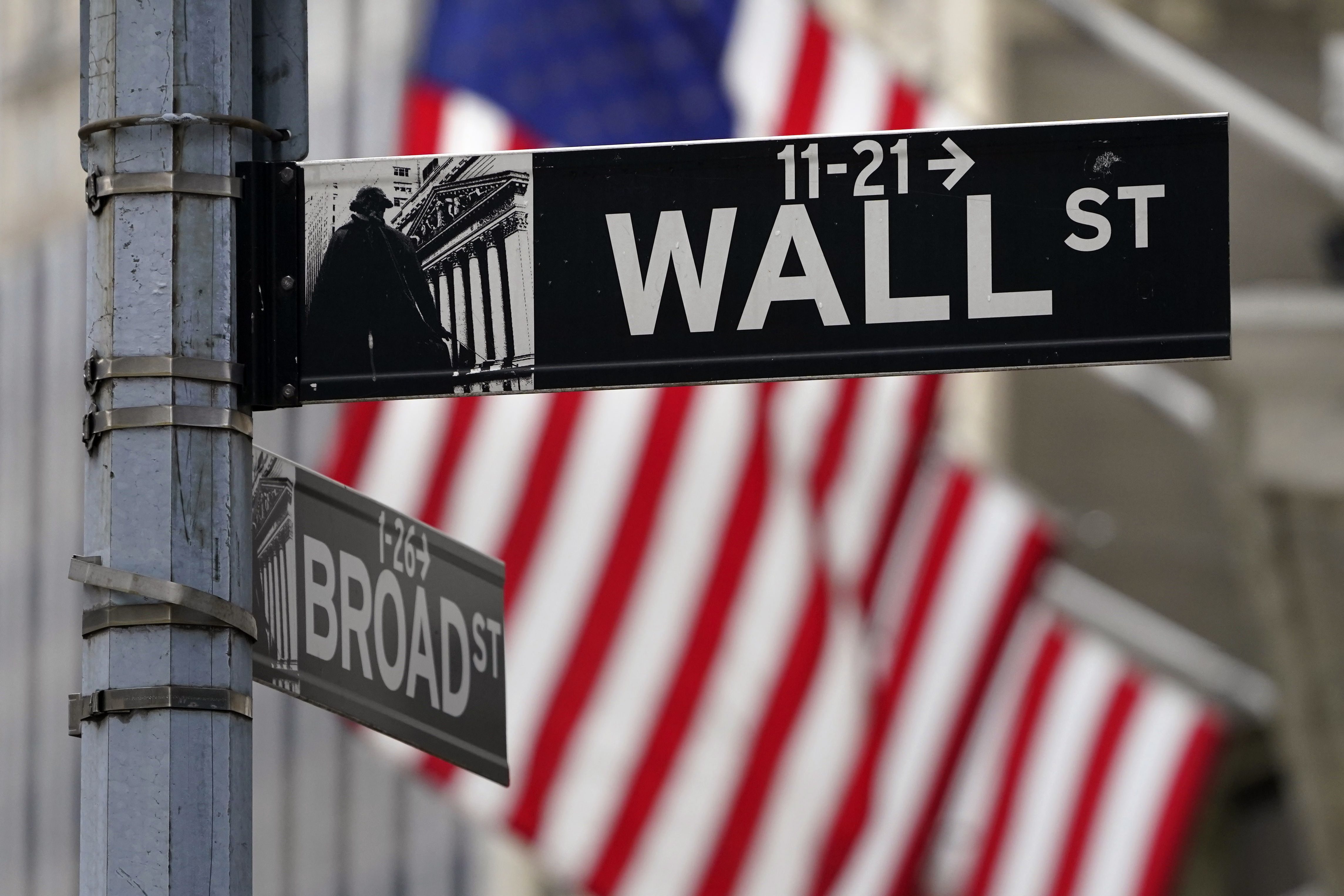 A Wall Street sign is displayed outside of the New York Stock Exchange in New York on Nov. 23, 2020. Following a worse-than-expected inflation report on Friday, U.S. stock indexes were down across the board on Monday.
