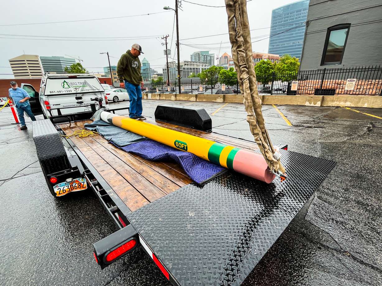 Construction crews prepared to hoist a pencil public art sculpture to its home outside of a business located on South Temple in Salt Lake City Monday morning. The pencil was made from a repurposed utility pole.