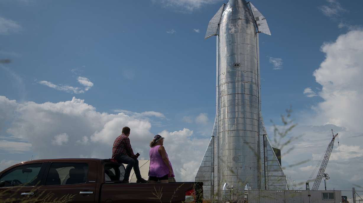 Space enthusiasts look at a prototype of SpaceX's Starship spacecraft at the company's Texas launch facility on Sept. 28, 2019 in Boca Chica near Brownsville, Texas. The Starship spacecraft is a massive vehicle meant to take people to the Moon, Mars and beyond.