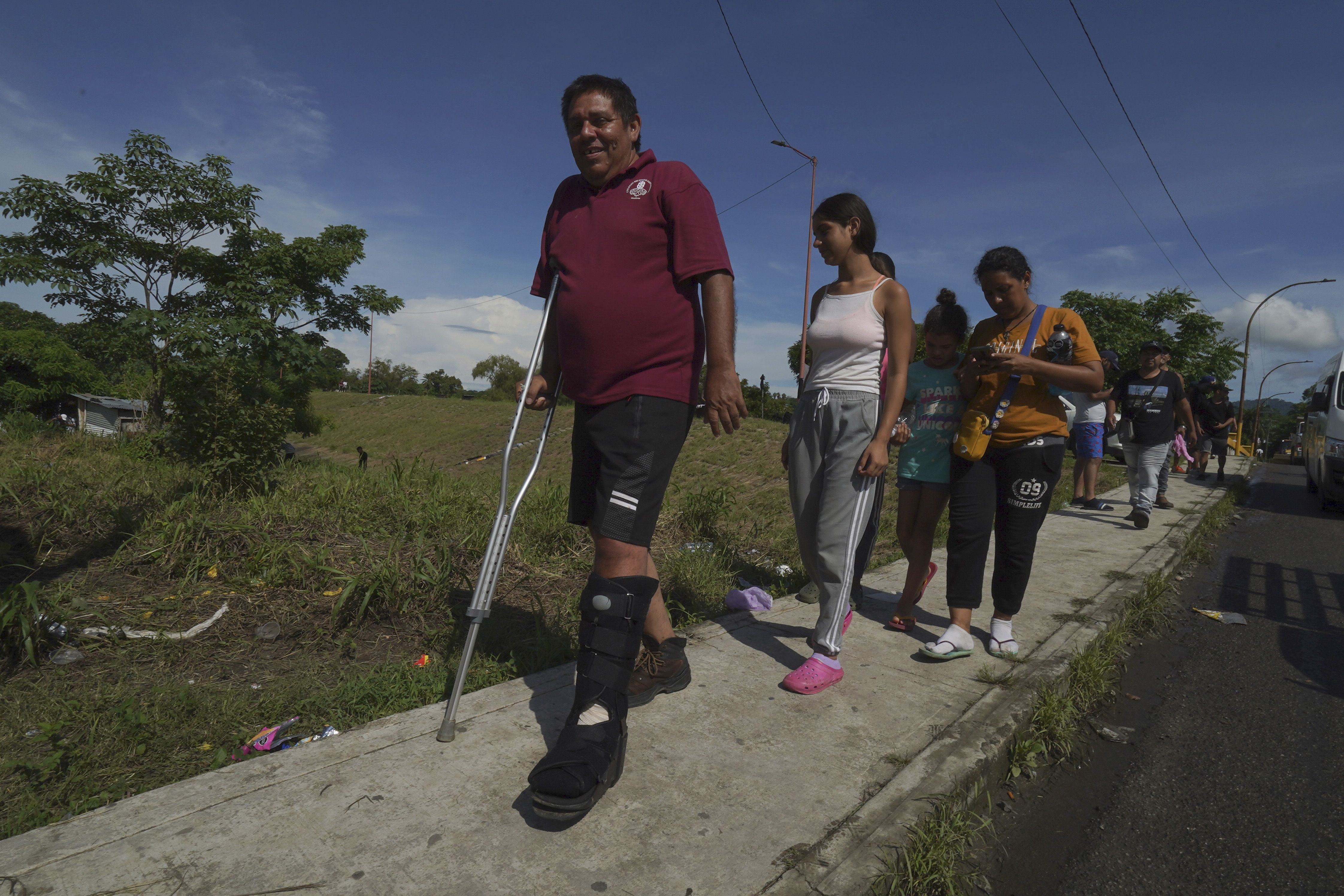 Venezuelan migrant Jesus Gonzalez, who broke his leg while crossing the Darien jungle, walks with his family who are part of a migrant caravan that has stopped to rest in Huixtla, Chiapas state, Mexico, on Wednesday. Venezuelans make up a large proportion of this caravan, the biggest of the year, in contrast to others in previous years.