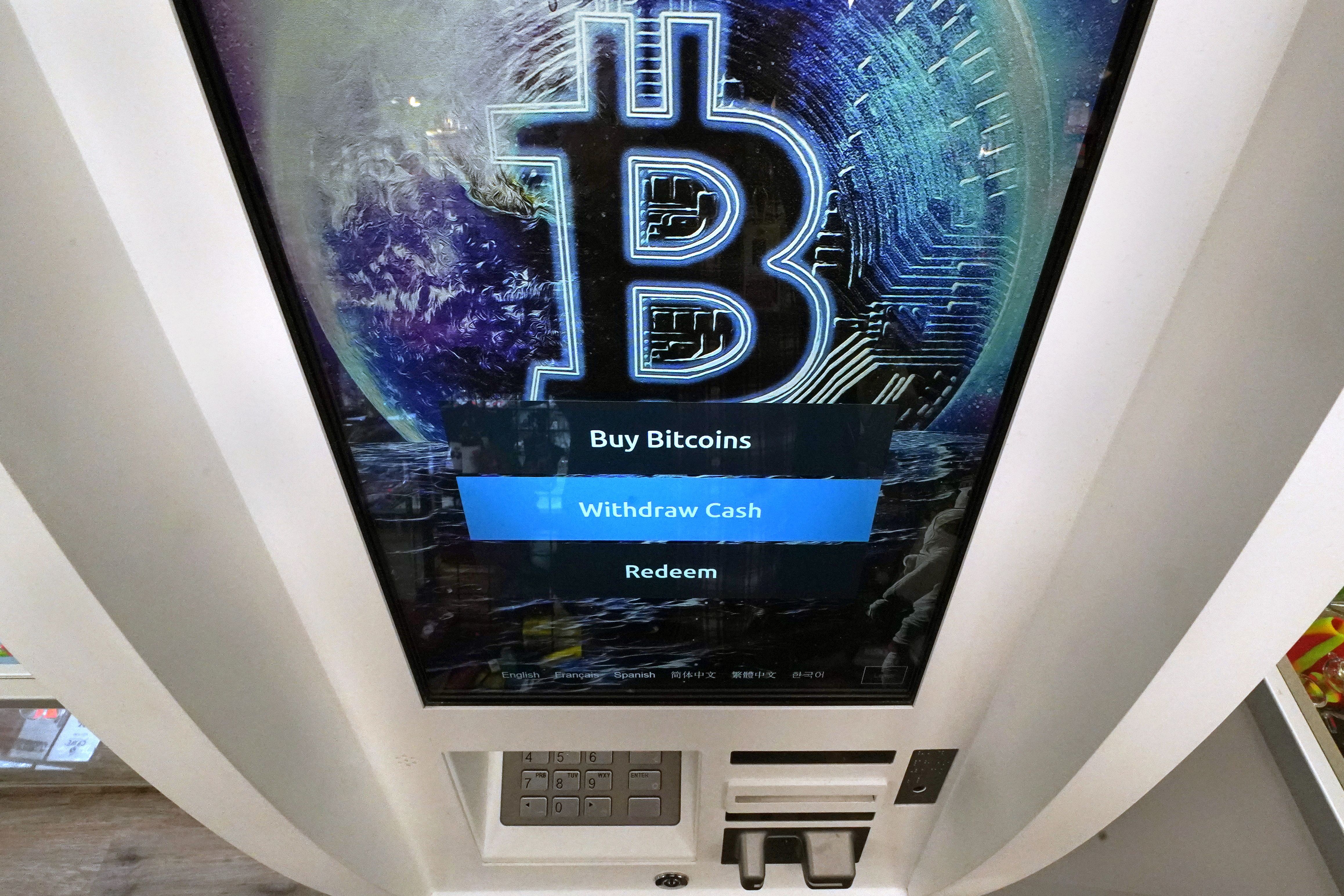 The Bitcoin logo appears on the display screen of a cryptocurrency ATM in Salem, N.H. Major cryptocurrencies were down on Monday after a rough weekend in which the overall digital currency market lost some $200 billion in value.