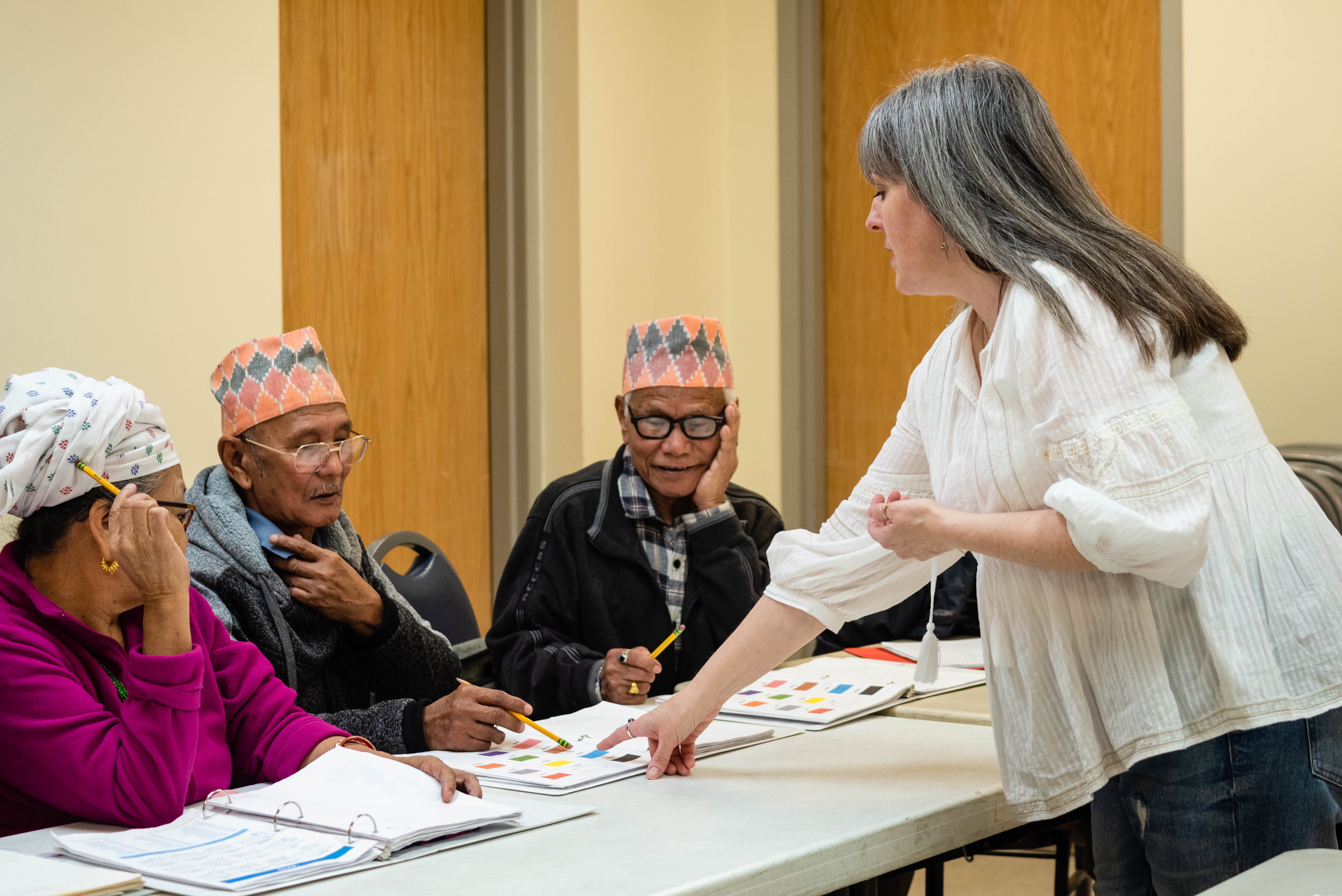 Adult learners and their teacher in a community English language class available through the English Skills Learning Center.