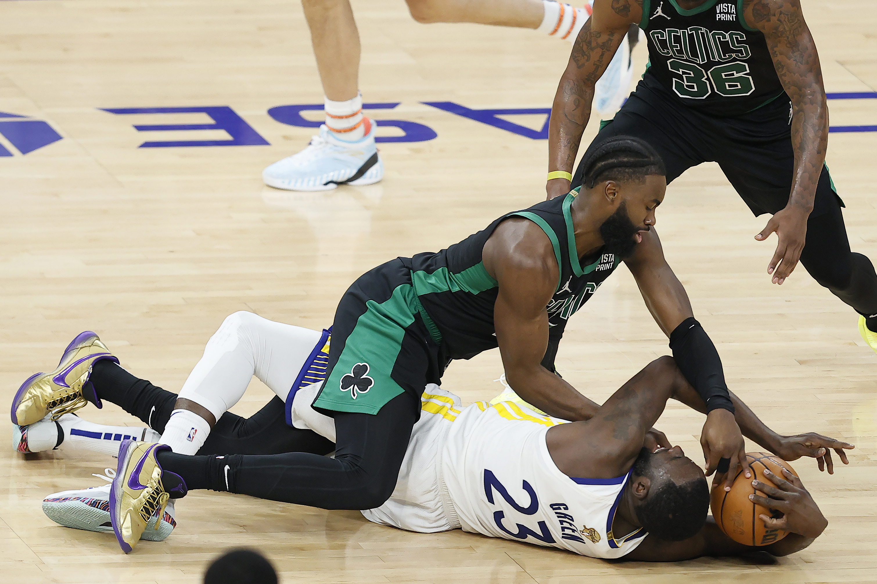 Golden State Warriors forward Draymond Green, bottom, tries to hold onto the ball under Boston Celtics guard Jaylen Brown during the first half of Game 5 of basketball's NBA Finals in San Francisco, Monday, June 13, 2022. 