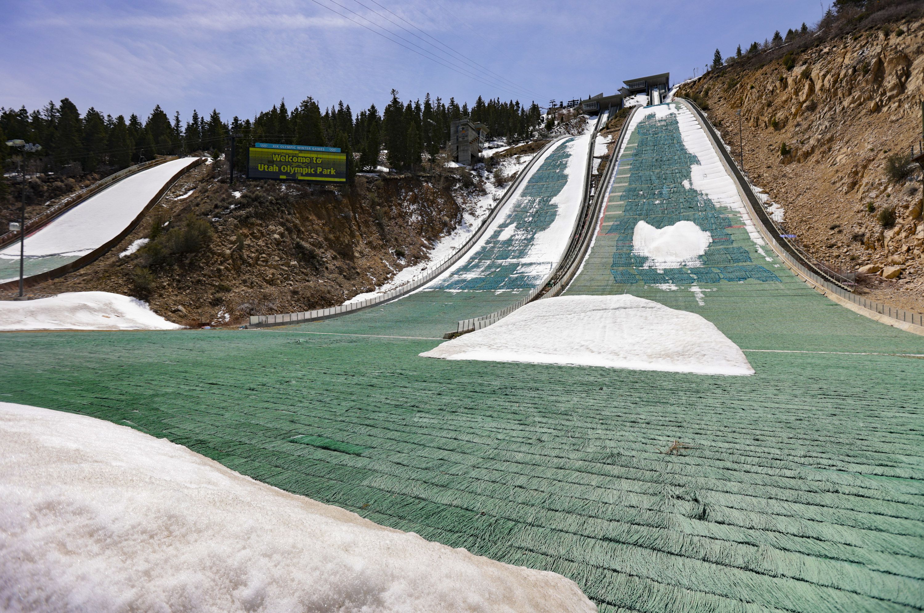 Snow on the K10/20 ski jump melts revealing the artificial grass underneath at the Utah Olympic Park in Park City on Monday, April 25.