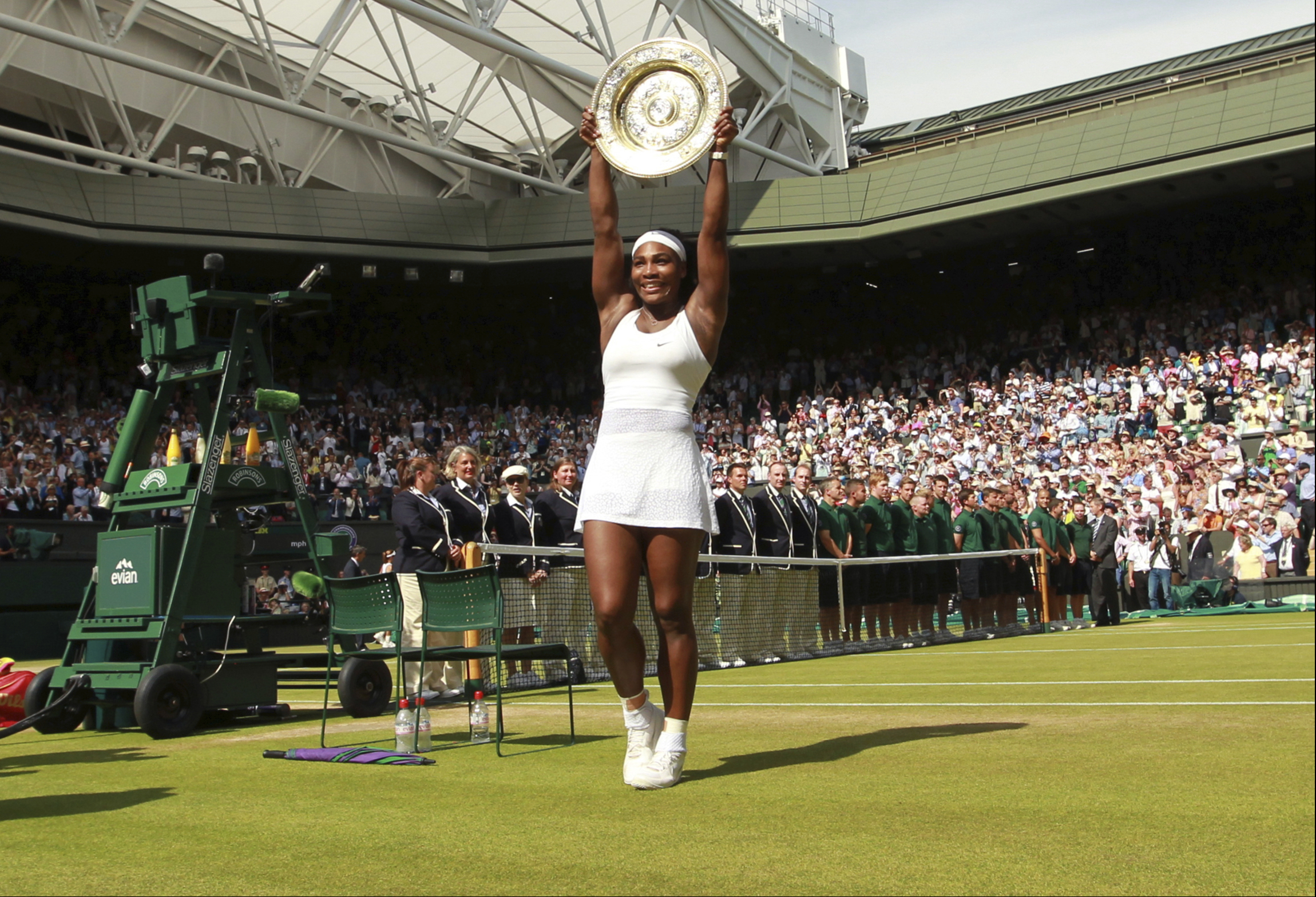 FILE - Serena Williams of the United States holds up the trophy after winning the women's singles final against Garbine Muguruza of Spain at the All England Lawn Tennis Championships in Wimbledon, London, Saturday, July 11, 2015. Chris Evert appreciates that she, Serena Williams and other Wimbledon women's singles champions will now be listed on the All England Club's honor boards in a Centre Court hallway simply by their first initial and last name — the way the men's title winners always have been — instead of preceded by “Miss” or “Mrs.”