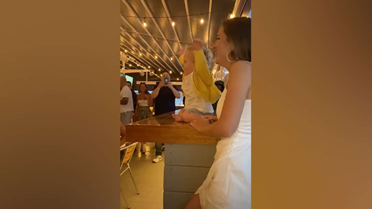 A baby entertains a restaurant full of adults.