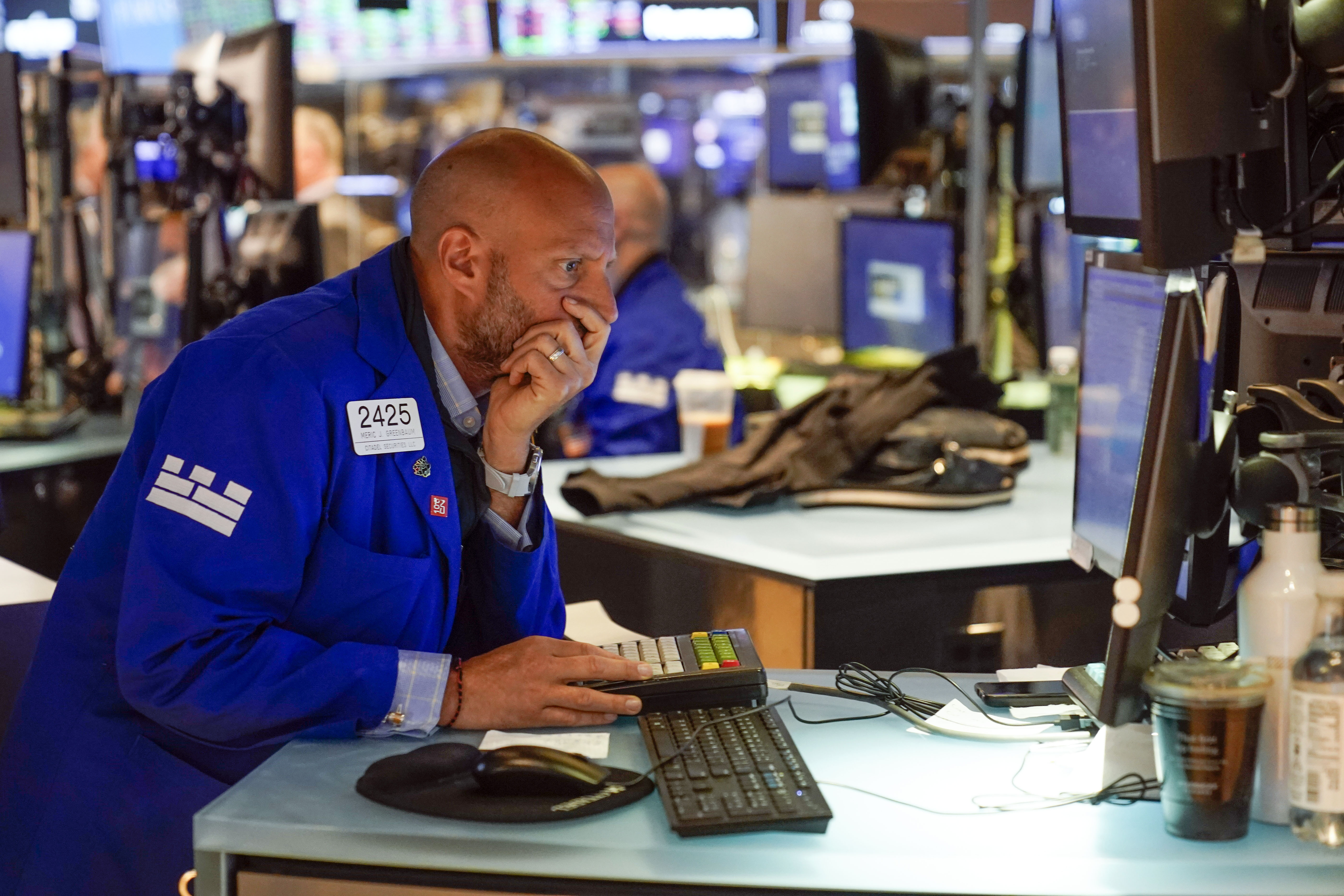 Traders work on the floor at the New York Stock Exchange in New York, Tuesday. Wall Street is wobbling between gains and losses Tuesday in its first trading after tumbling into a bear market on worries about a fragile economy and rising rates.