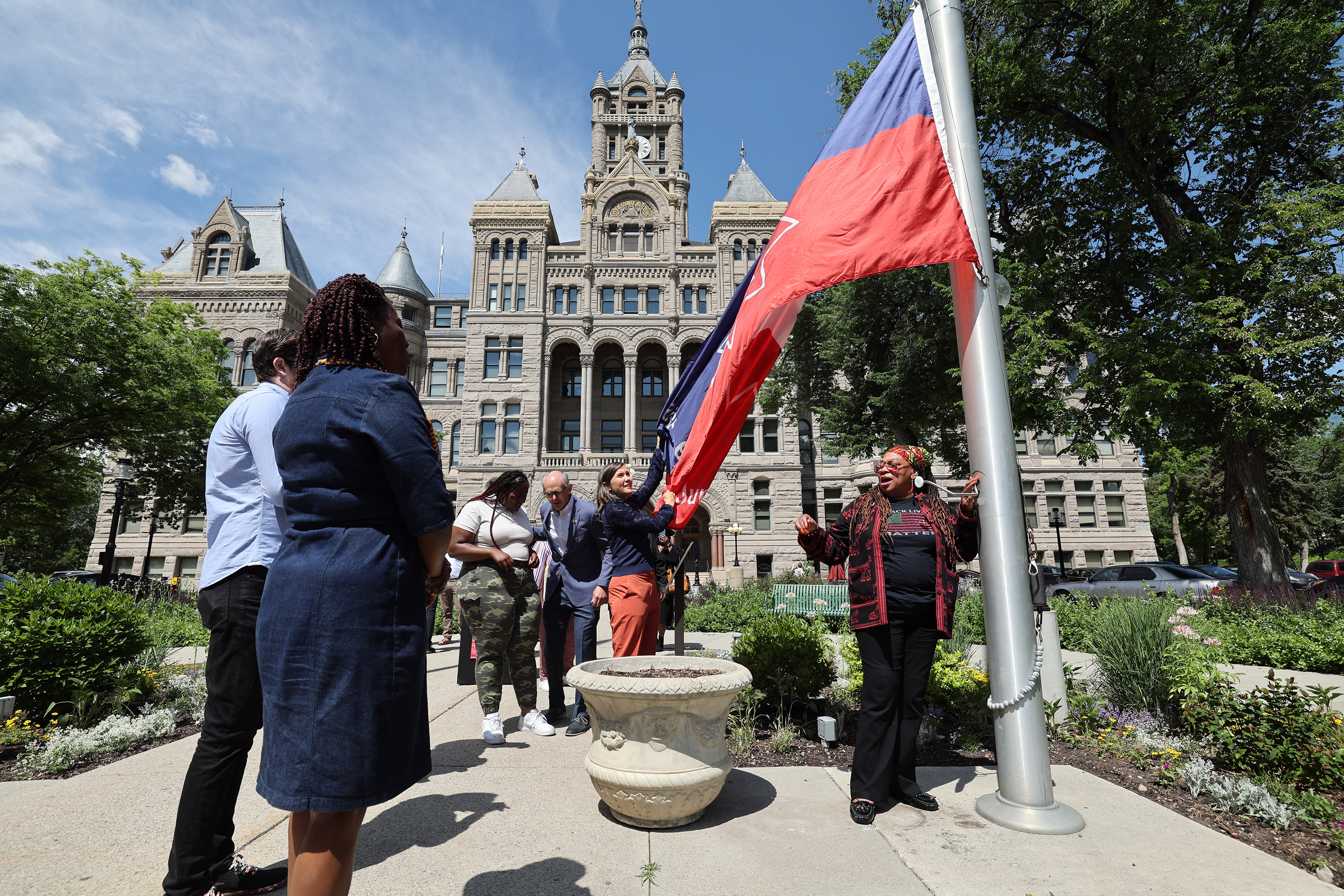 Leaders from the Black community, Salt Lake City Council, law enforcement and the state take turns raising the Juneteenth flag at the Salt Lake City-County Building on Tuesday.