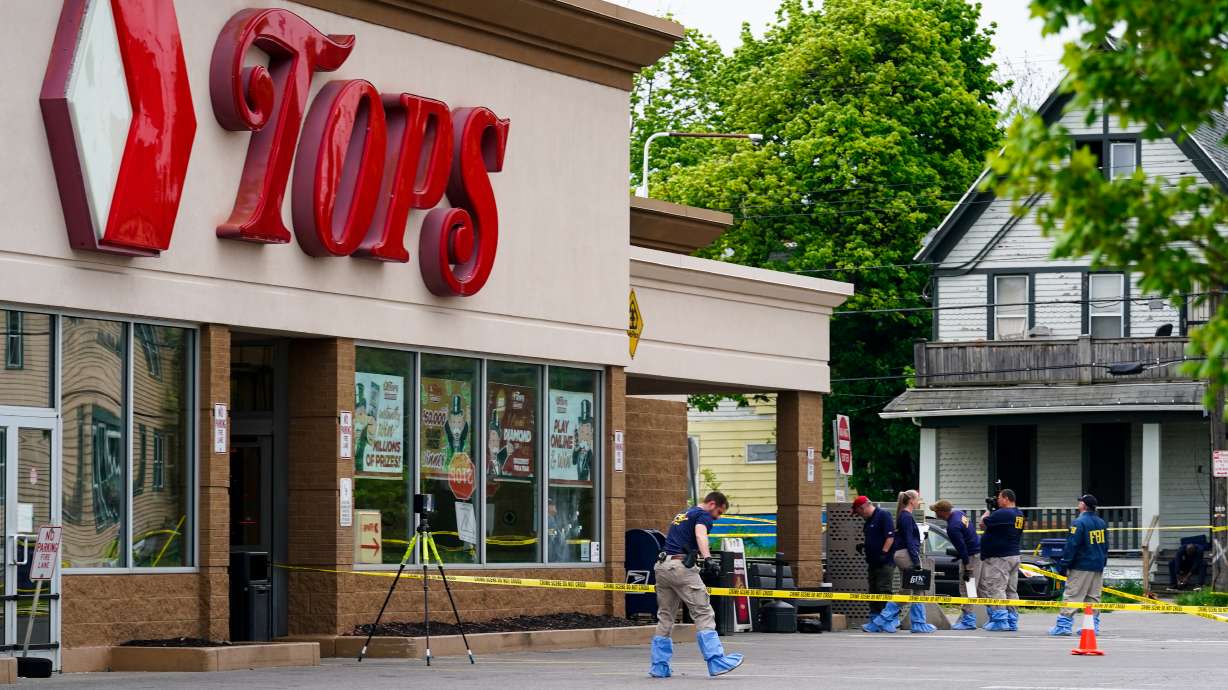 Investigators work the scene after a mass shooting at a supermarket, in Buffalo, N.Y., May 16. The gunman who killed 10 Black people in a racist attack at a Buffalo supermarket has been charged Wednesday with federal hate crimes and could face the death penalty.