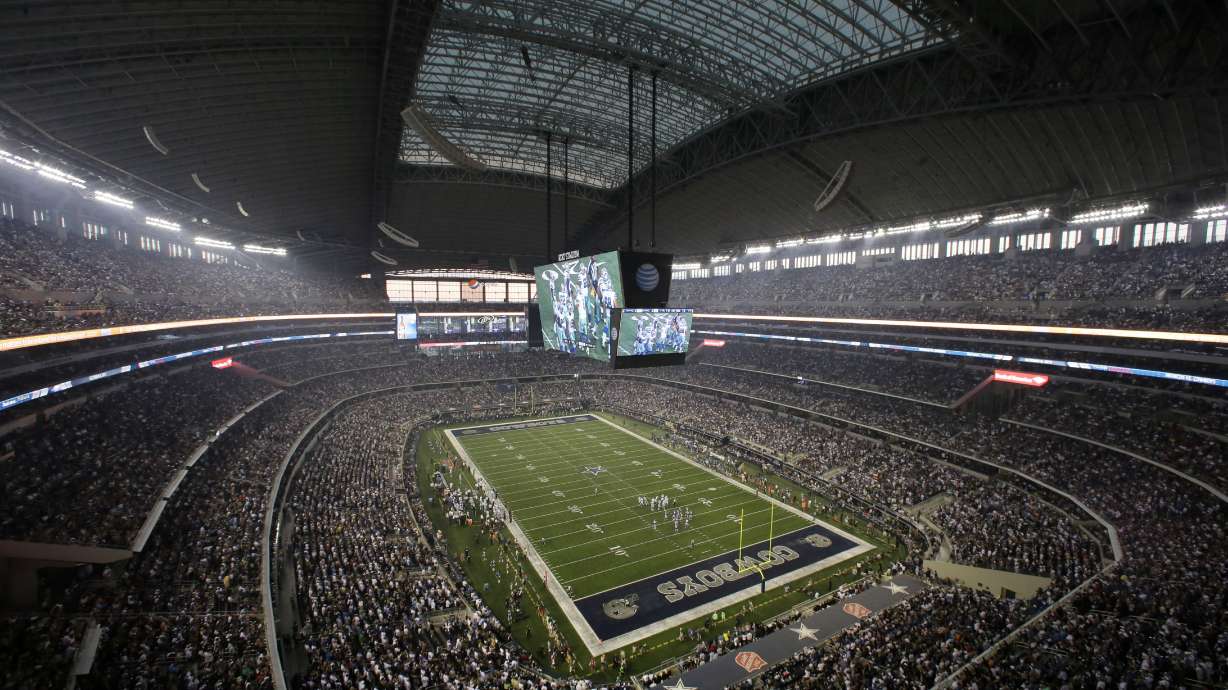 FILE - Fans watch at the start of an NFL football game inside AT&T Stadium between the New York Giants and Dallas Cowboys, Sunday, Sept. 8, 2013, in Arlington, Texas. There are 23 venues bidding to host soccer matches at the 2026 World Cup in the United States, Mexico and Canada.