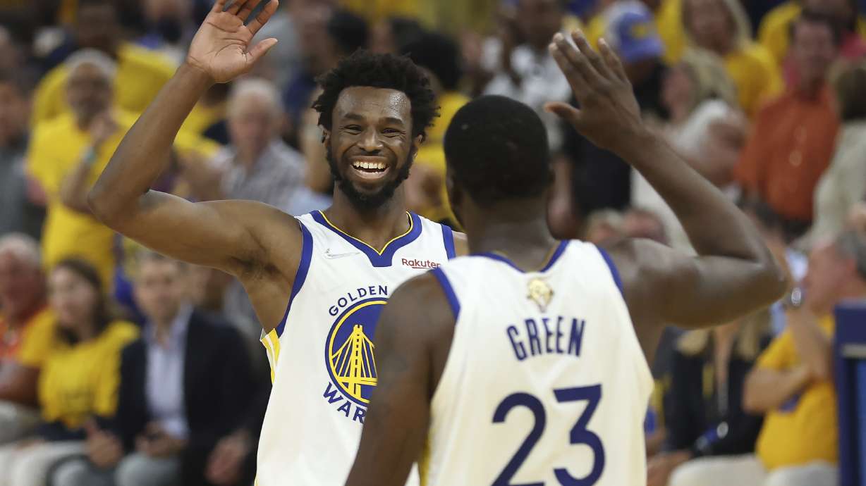 Golden State Warriors forward Andrew Wiggins, left, celebrates with forward Draymond Green (23) during the first half of Game 5 of basketball's NBA Finals against the Boston Celtics in San Francisco, Monday, June 13, 2022.