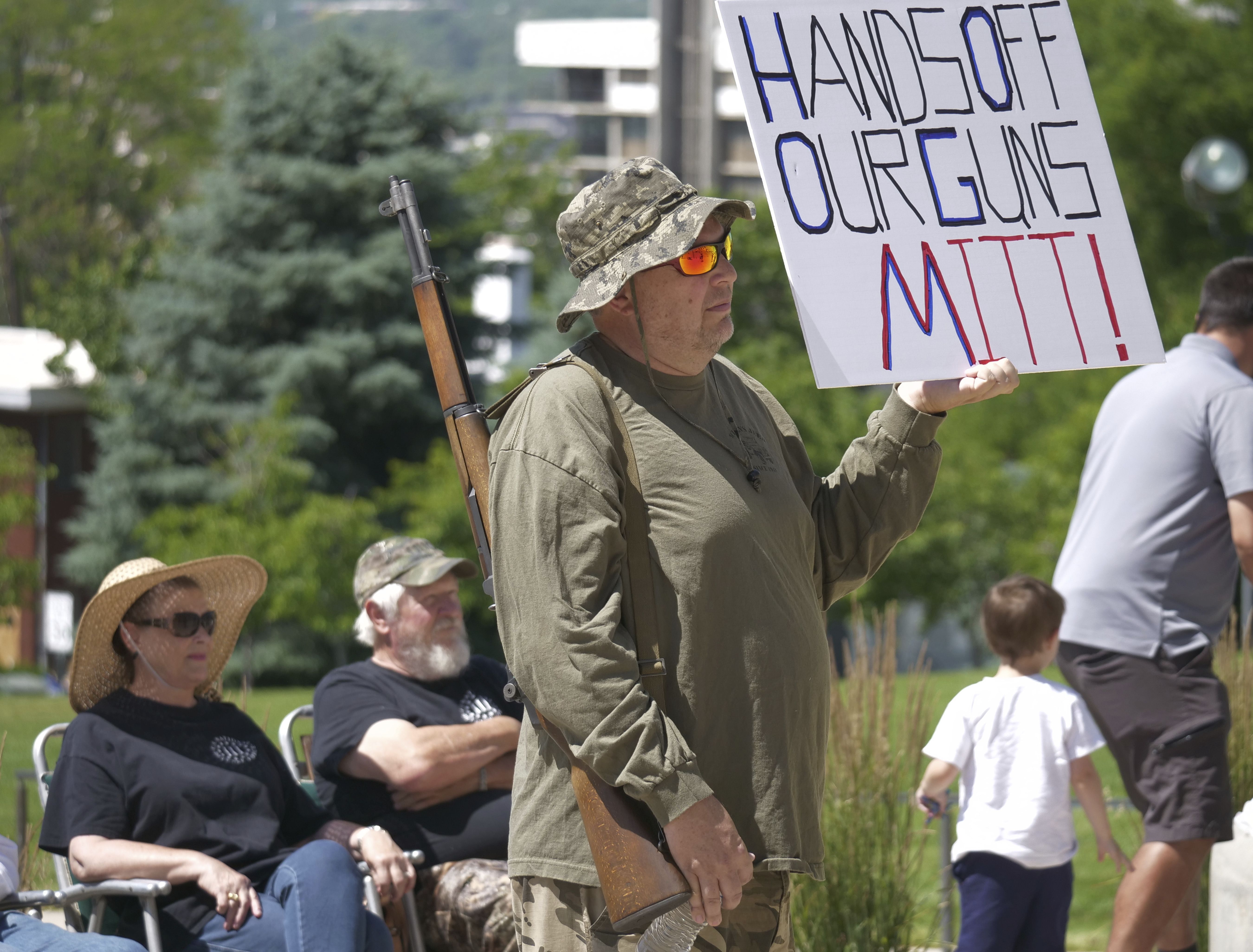 Steve Jensen looks on as he holds a sign reading, “Hands off our guns Mitt,” during a Second Amendment rally at the Utah Capitol, in Salt Lake City on June 16, 2018. There are lines Sen. Mitt Romney says he would not cross as a bipartisan group of senators works to draft legislation from a framework on gun safety measures unveiled this week.