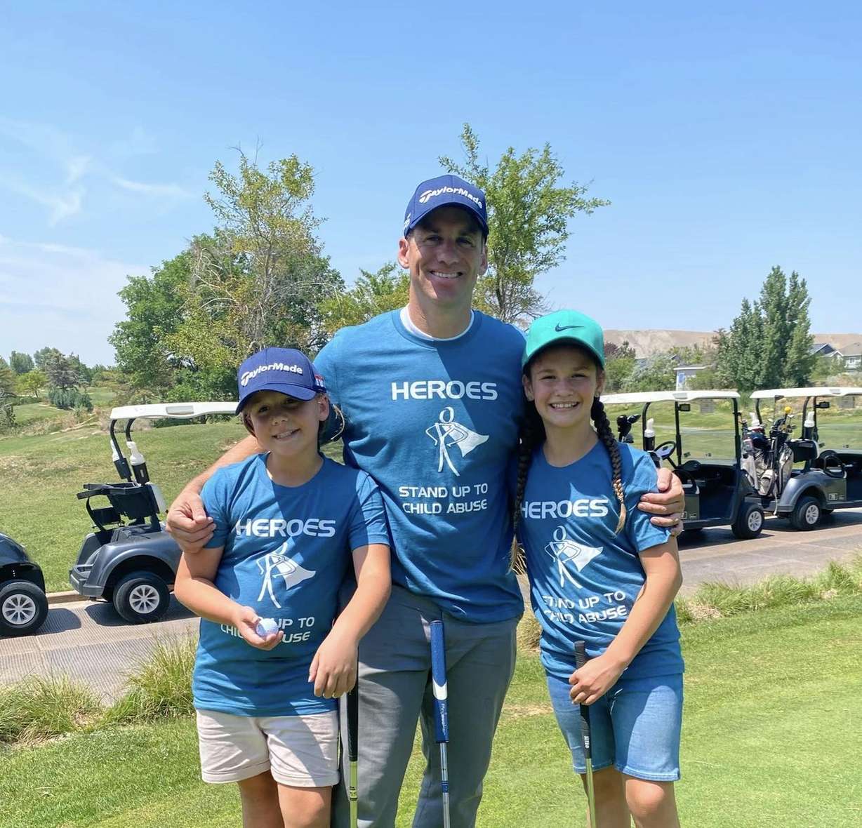 Adam Welch poses with two of his children at the 2021 Father's Day Classic golf tournament to raise awareness and funding to precent child abuse in Utah.