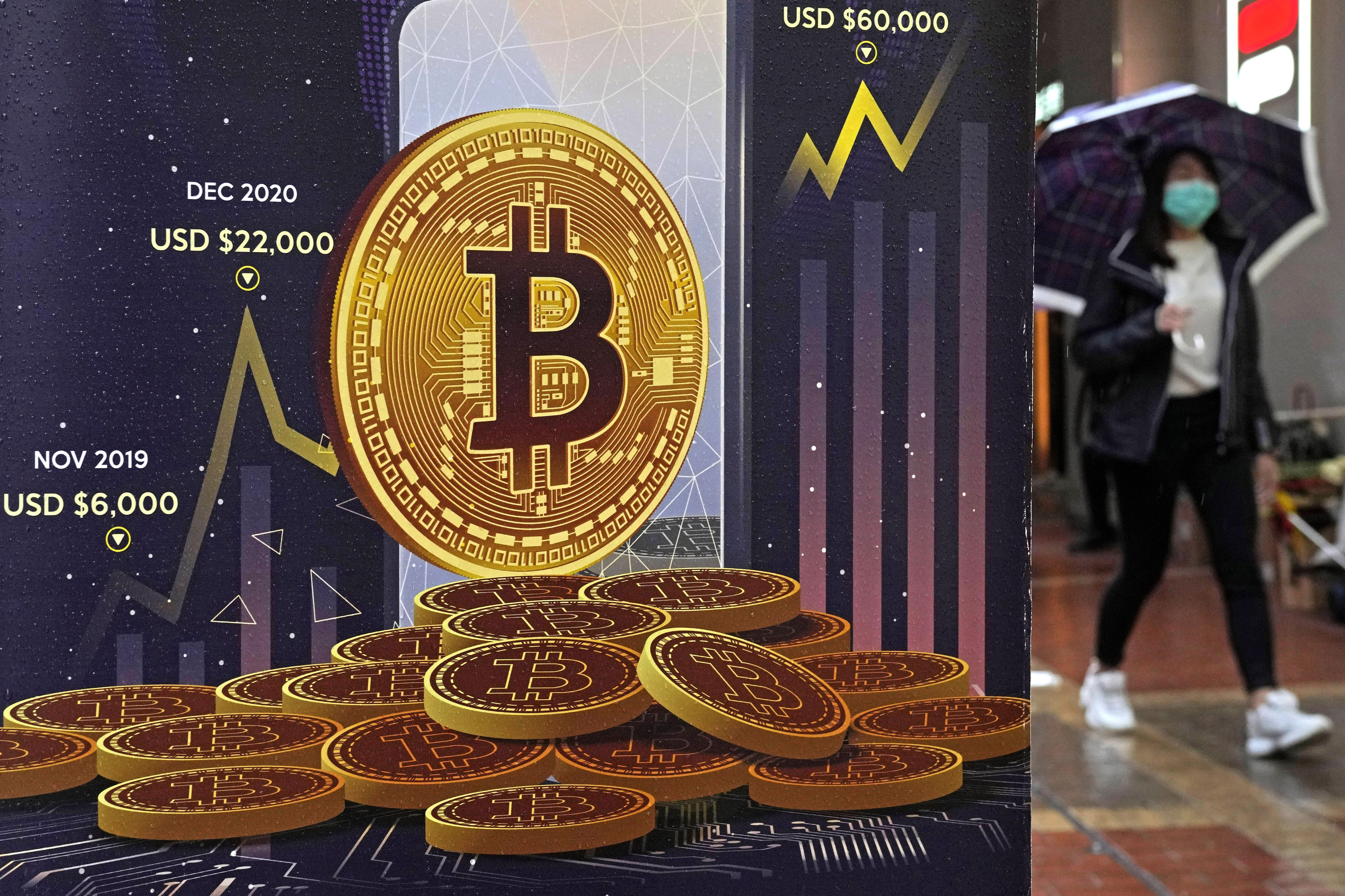 An advertisement for bitcoin cryptocurrency is displayed on a street in Hong Kong on Feb. 17. The downward slide of cryptocurrency over the last couple of months has sent skittish investors into retreat mode.
