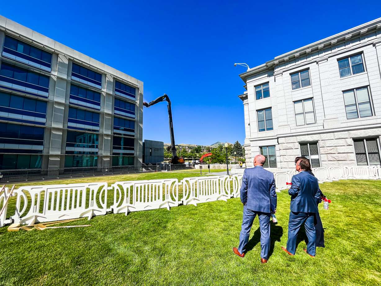 Utah Lt. Gov. Deidre Henderson, Senate President Stuart Adams, Gov. Spencer Cox and House Speaker Brad Wilson watch as an excavator begins knocking down the old state office building at the Utah Capitol on Wednesday afternoon.