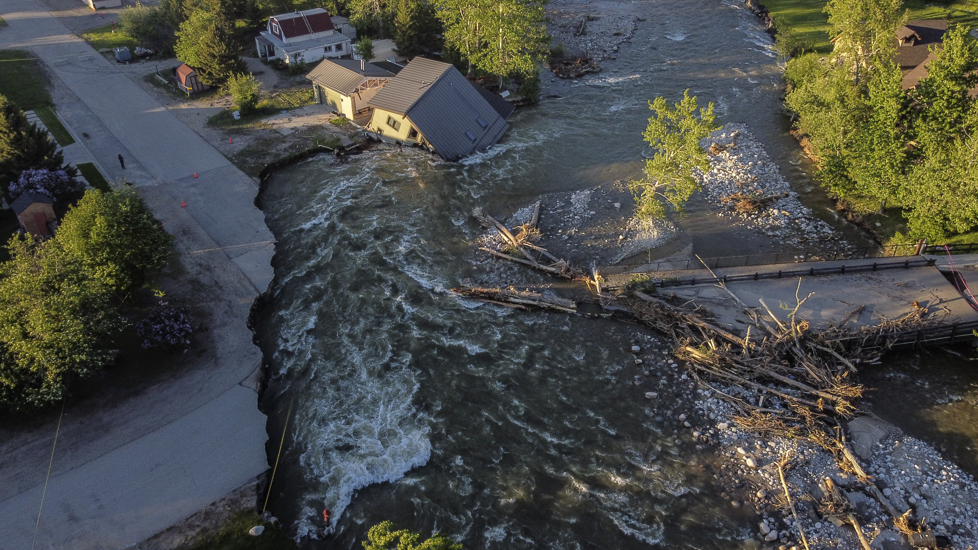A house sits in Rock Creek after floodwaters washed away a road and a bridge in Red Lodge, Mont., Wednesday.