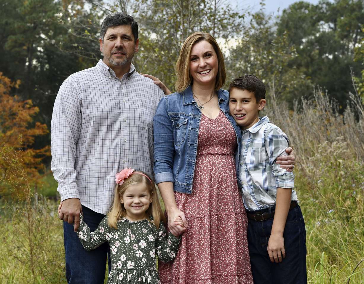 Reda Hicks appears with her husband Jake Hicks, left, daughter Katie and son Howard in Houston on Nov. 21, 2021. Reda Hicks, 41, was born and raised in Odessa, the epicenter of the West Texas oil industry. Her family is large, conservative and deeply evangelical. Her move to Austin for college was an eye opener. She has watched friction among friends and family from her two very different worlds devolve on her social media feeds.