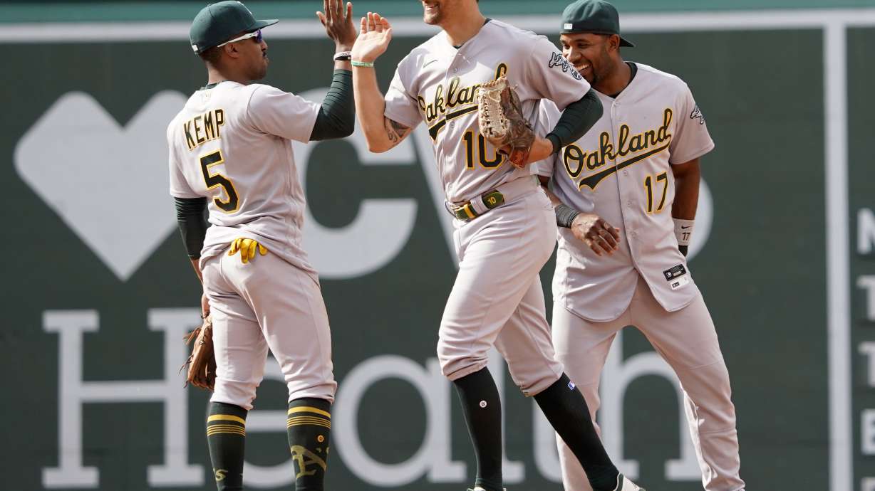 Oakland Athletics players, from left, Tony Kemp (5), Chad Pinder, and Elvis Andrus (17) celebrate after defeating the Boston Red Sox in a baseball game at Fenway Park, Thursday, June 16, 2022, in Boston.