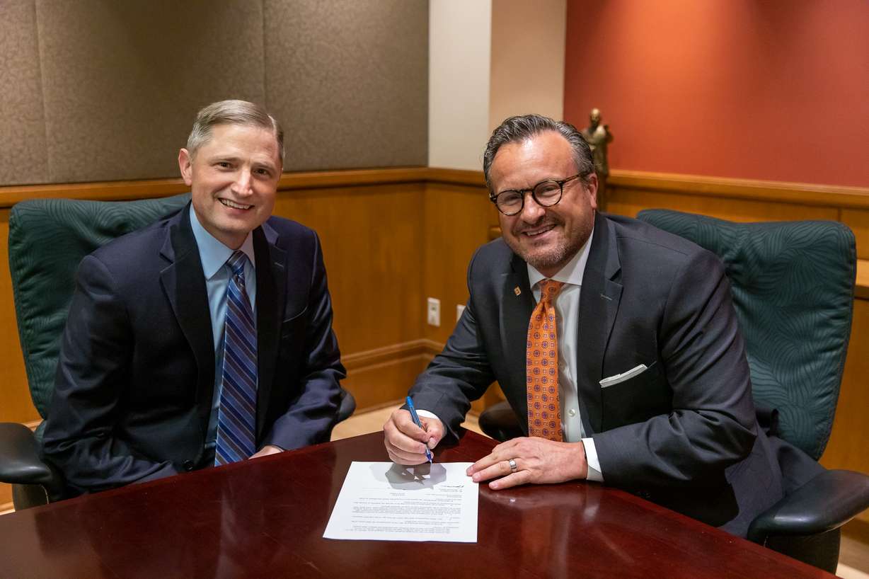 Jeremy Wells, left, chancellor at the Roseman University South Jordan campus and Snow College President Bradley J. Cook, right, sign an articulation agreement between the two institutions. Students pursuing a degree in health professions will now have the option to fast-track their degree through a new partnership between Snow College and Roseman University.