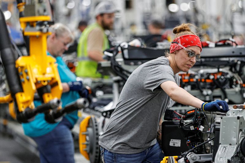 An employee works on an assembly line at startup Rivian Automotive's electric vehicle factory in Normal, Ill. April 11. The White House will launch a summer-long initiative on Friday to encourage labor unions and industry to work together to train more workers for good jobs in the electric vehicle, broadband and construction sectors.