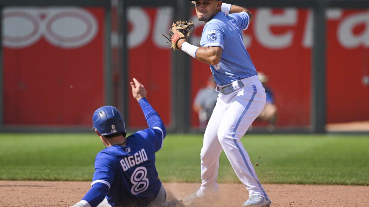 Kansas City Royals second baseman Nicky Lopez gets the force out on Toronto Blue Jays' Cavan Biggio at second, but couldn't make the play to first during the ninth inning of a baseball game, Wednesday, June 8, 2022, in Kansas City, Mo.