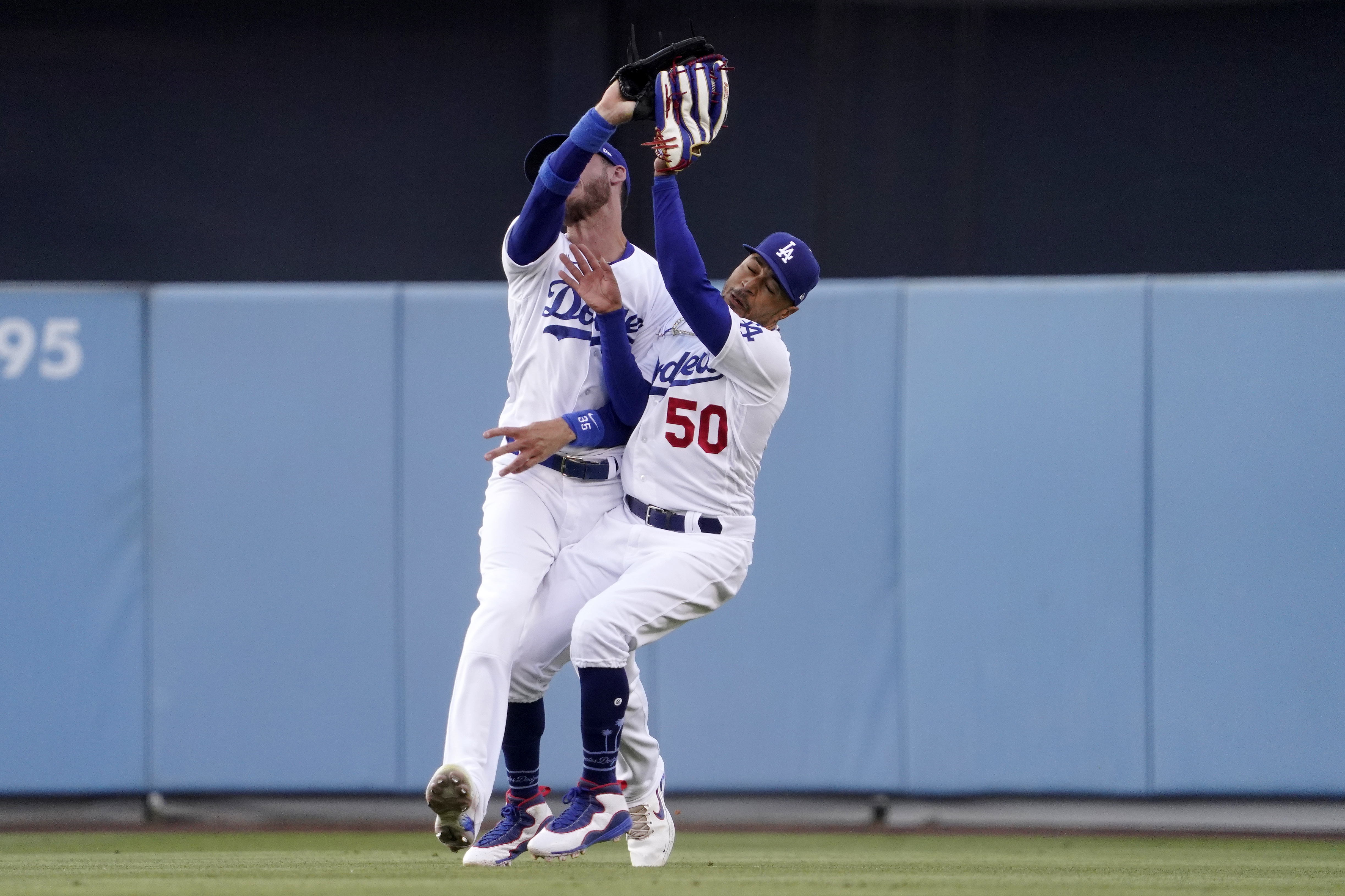 Los Angeles Dodgers right fielder Mookie Betts, right, collides with center fielder Cody Bellinger after making a catch on a ball hit by Los Angeles Angels' Taylor Ward during the first inning of a baseball game Wednesday, June 15, 2022, in Los Angeles. Betts lost control of the ball after the collision but Ward was thrown out at second by Bellinger. 