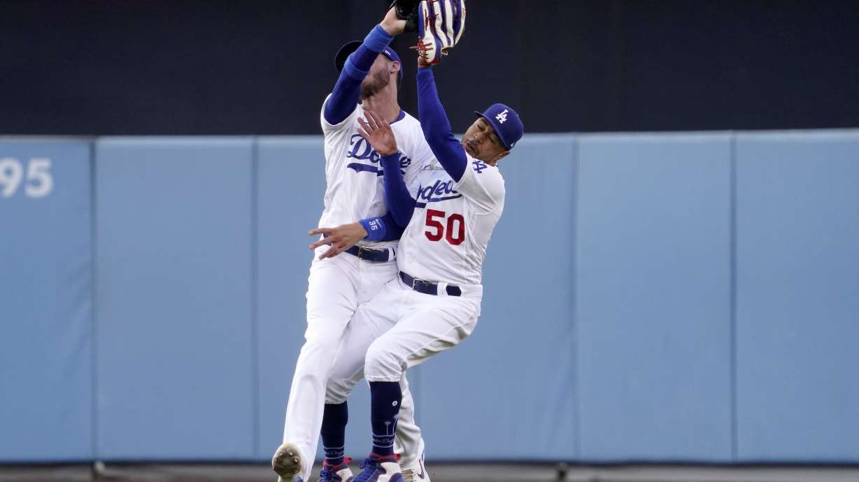 Los Angeles Dodgers right fielder Mookie Betts, right, collides with center fielder Cody Bellinger after making a catch on a ball hit by Los Angeles Angels' Taylor Ward during the first inning of a baseball game Wednesday, June 15, 2022, in Los Angeles. Betts lost control of the ball after the collision but Ward was thrown out at second by Bellinger.