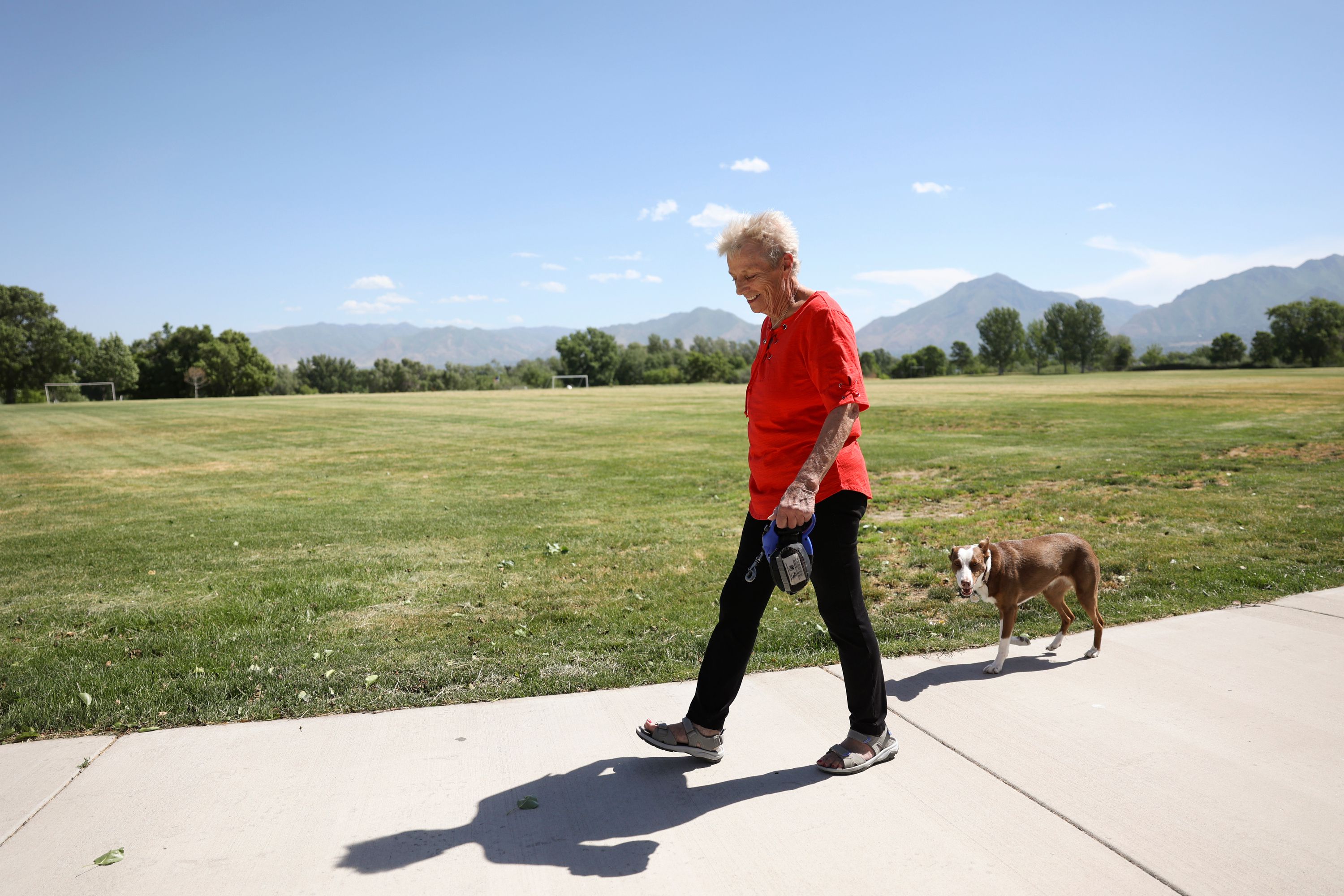 A woman walks her dog around the Salt Lake County Rugby Fields in Murray on Friday. Salt Lake County is planning to replace some park strips and athletic fields with water-wise landscaping and artificial turf.