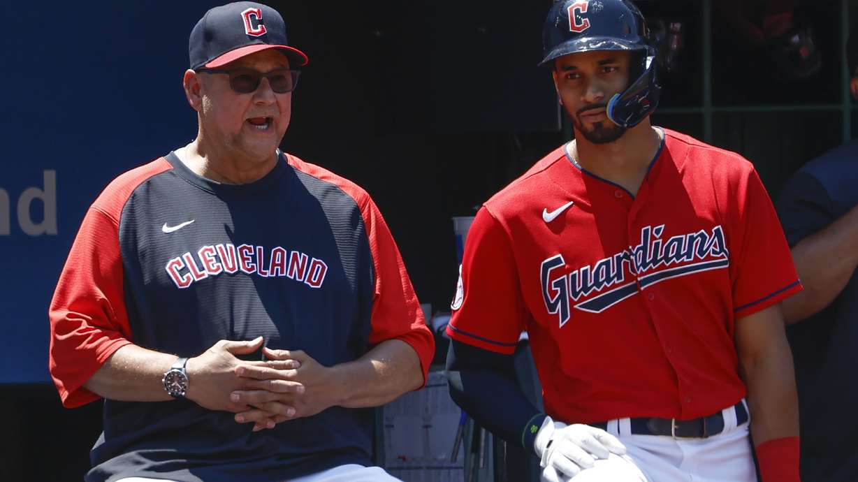 Cleveland Guardians manager Terry Francona, left, talks with Oscar Mercado during the eighth inning of a baseball game against the Oakland Athletics, Sunday, June 12, 2022, in Cleveland.