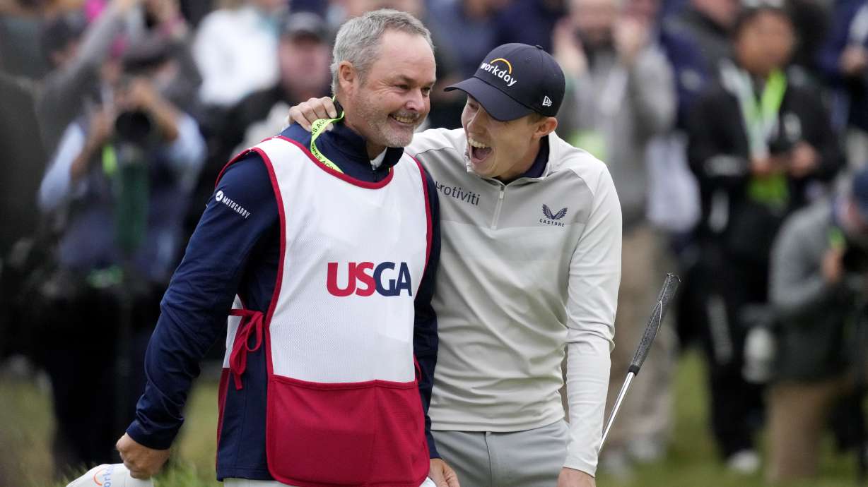 Matthew Fitzpatrick, of England, celebrates with his caddie after winning the U.S. Open golf tournament at The Country Club, Sunday, June 19, 2022, in Brookline, Mass.