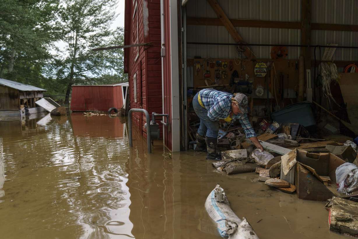 Lindi O'Brien sorts through personal mementos in the barn of her parent's home badly damaged by the severe flooding in Fromberg, Mont., Friday.