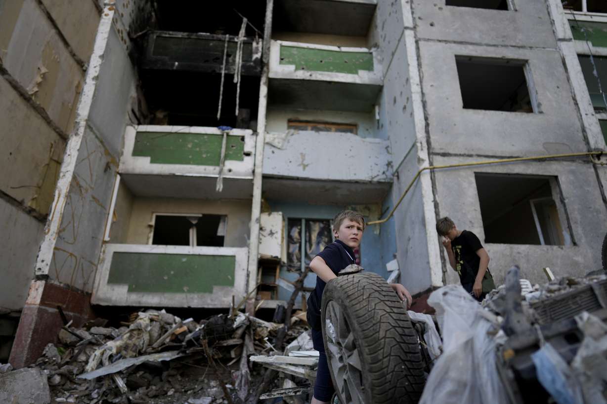 Children stand in front of a building destroyed by attacks in Chernihiv, Ukraine, Sunday.
