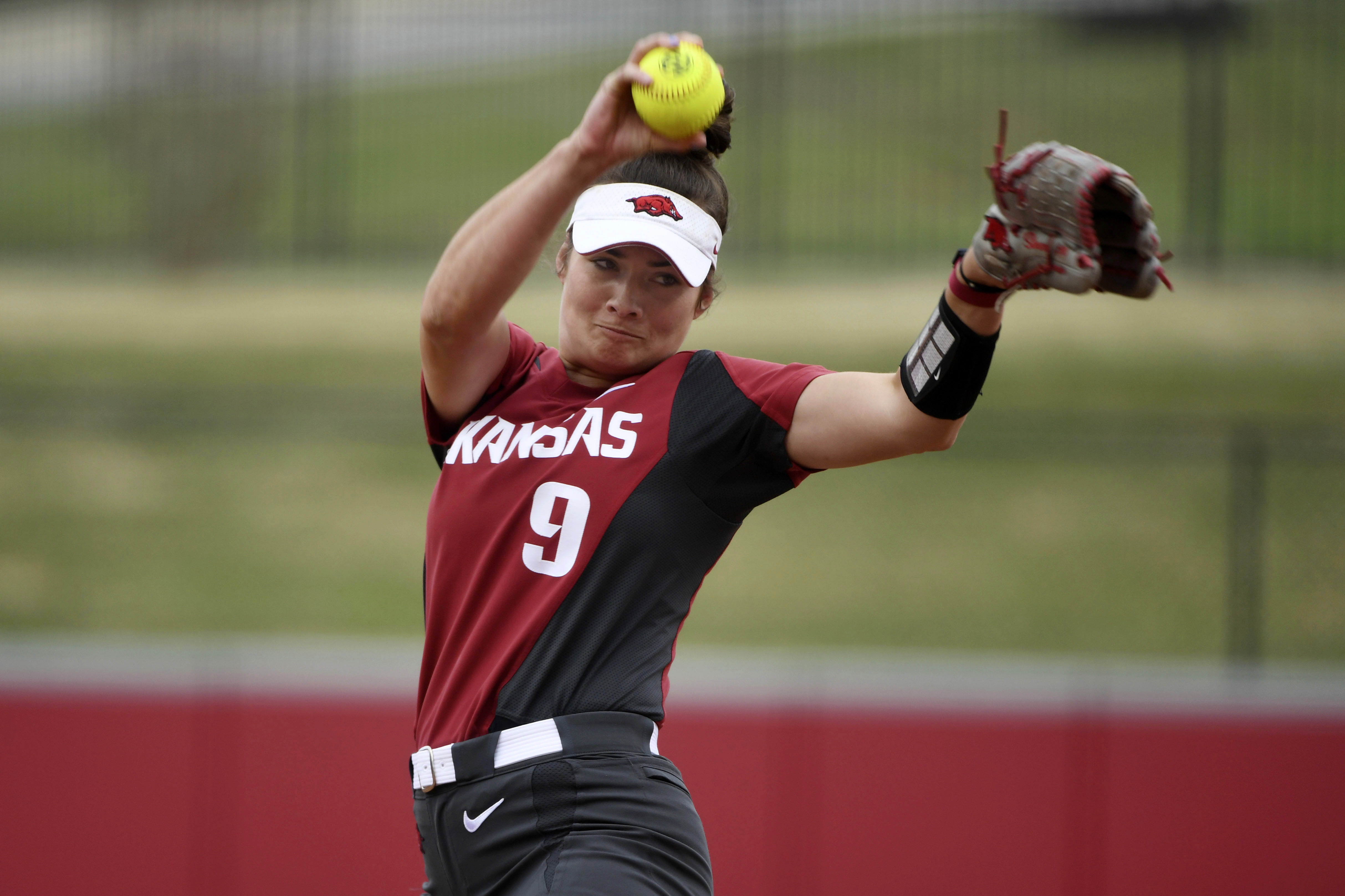 FILE - Arkansas pitcher Autumn Storms throws a pitch against Arkansas-Pine Bluff during an NCAA softball game on Tuesday, April 16, 2019 in Fayetteville, Ark. Arkansas did something rare during the 2017-18 and 2018-19 seasons: It watched its baseball and softball teams both reach the NCAA tournament. The similarities end there.