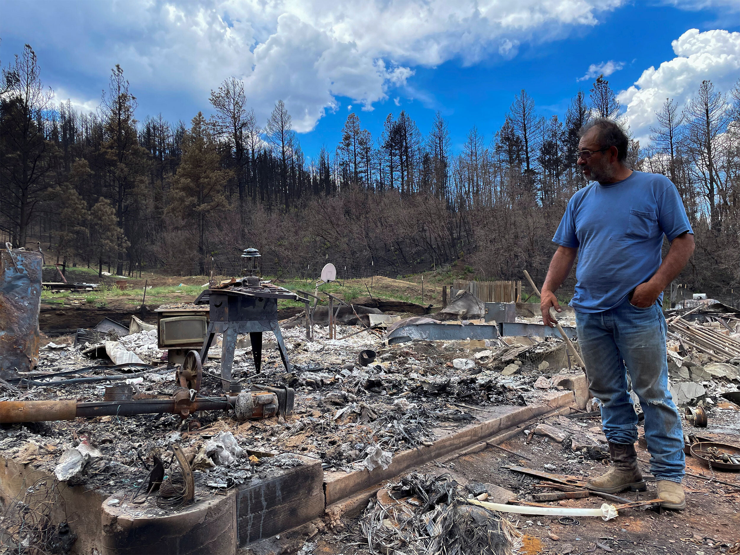 Daniel Encinias stands next to the ruins of his home, which was destroyed by the Hermits Peak/Calf Canyon fire in Tierra Monte, New Mexico.
