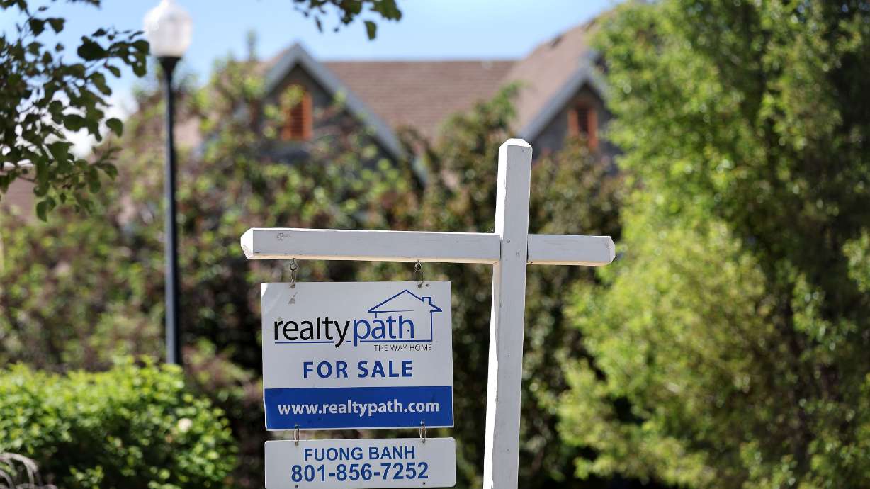A “for sale” sign is posted in the yard of a house in Sandy on May 31. Now that mortgage rates have surged to the 6% threshold, a global research company is now saying U.S. housing price growth is likely to fall — not this year, but next.