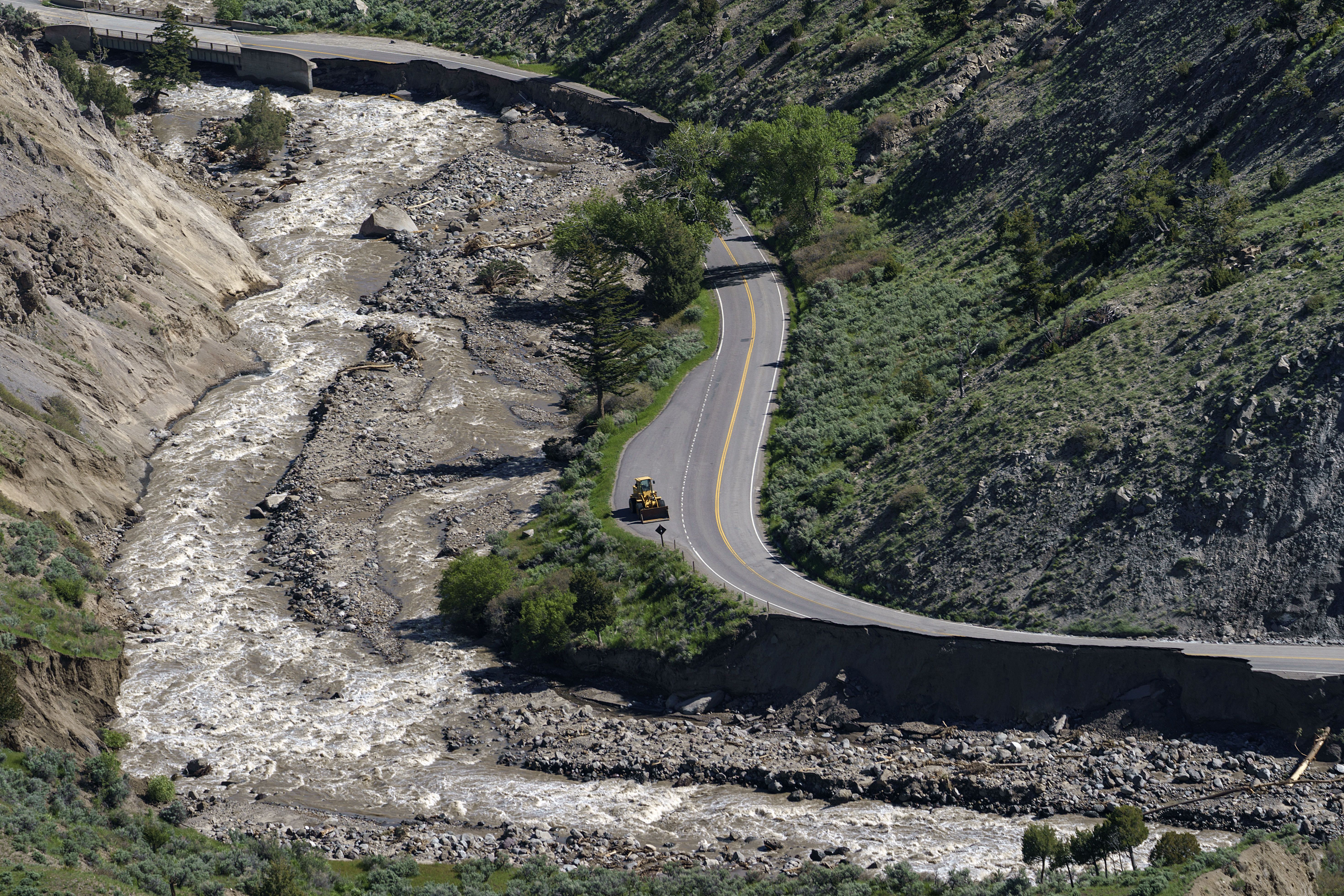 A bulldozer sits on North Entrance Road surrounded by sections washed away by recent floodwaters at Yellowstone National Park in Gardiner, Montana, on June 16. Historic flooding has caused extensive damage throughout the iconic national park.