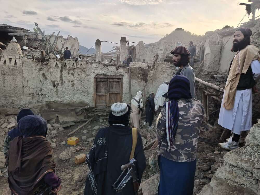 In this photo released by a state-run news agency Bakhtar, Afghans look at destruction caused by an earthquake in the province of Paktika, eastern Afghanistan, Wednesday.