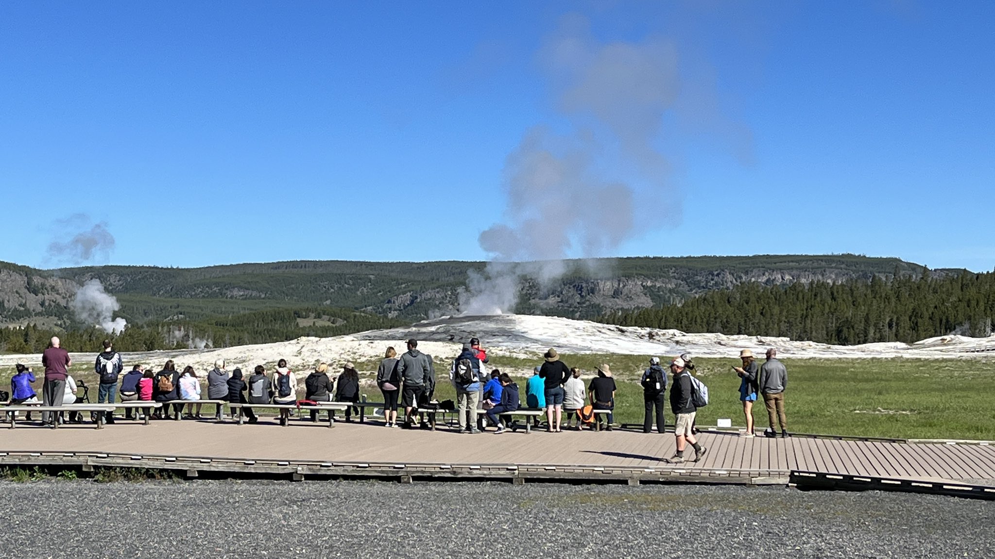Visitors view Old Faithful at Yellowstone National Park on Wednesday morning. The park reopened earlier in the day for the first time after flooding damage closed the park for over a week.