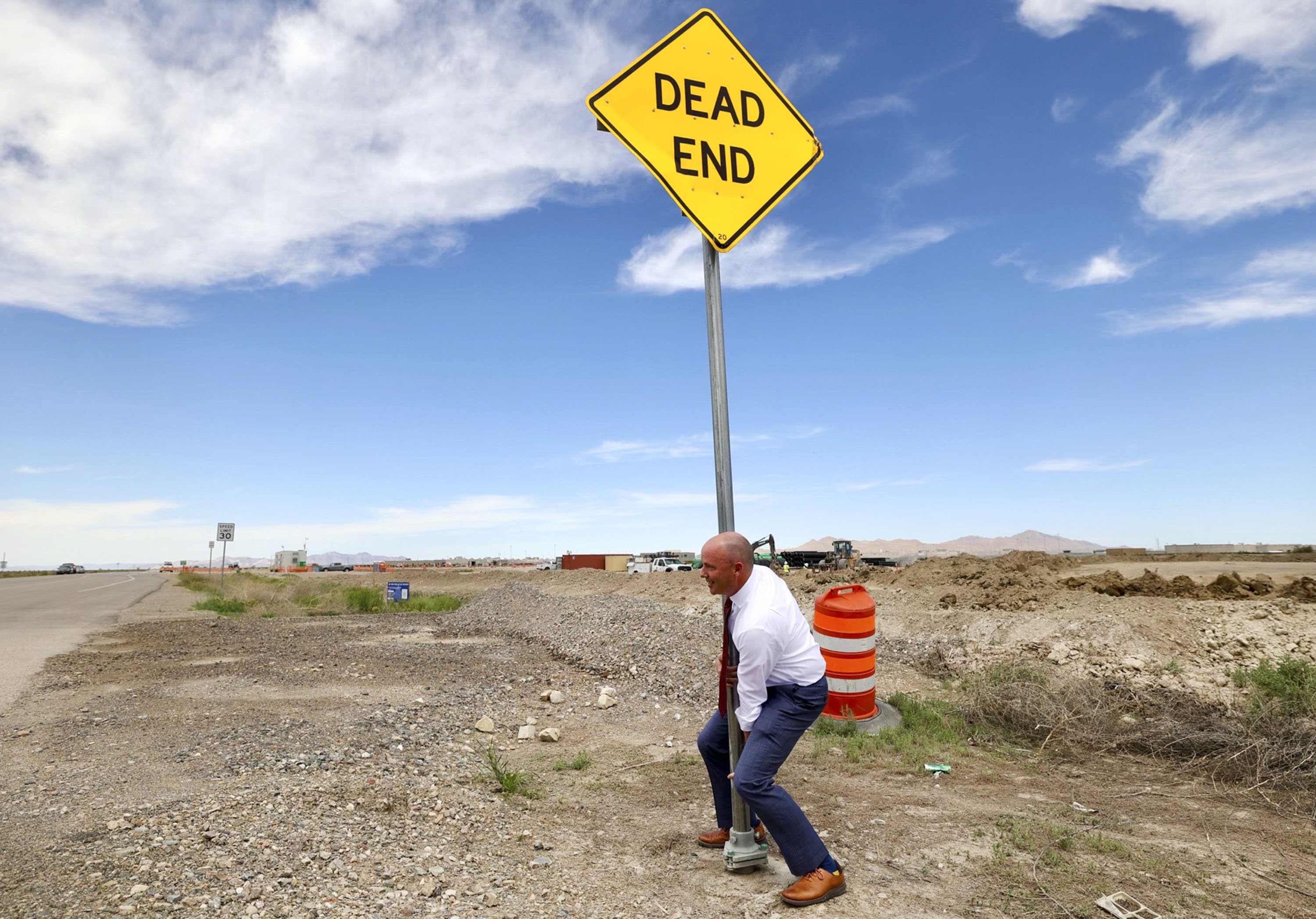 Gov. Spencer Cox takes down a “dead end” sign on the road leading to the new Utah State Correctional Facility, at the suggestion of House Speaker Brad Wilson, R-Kaysville, at a ribbon-cutting ceremony for the facility in Salt Lake City on Wednesday.