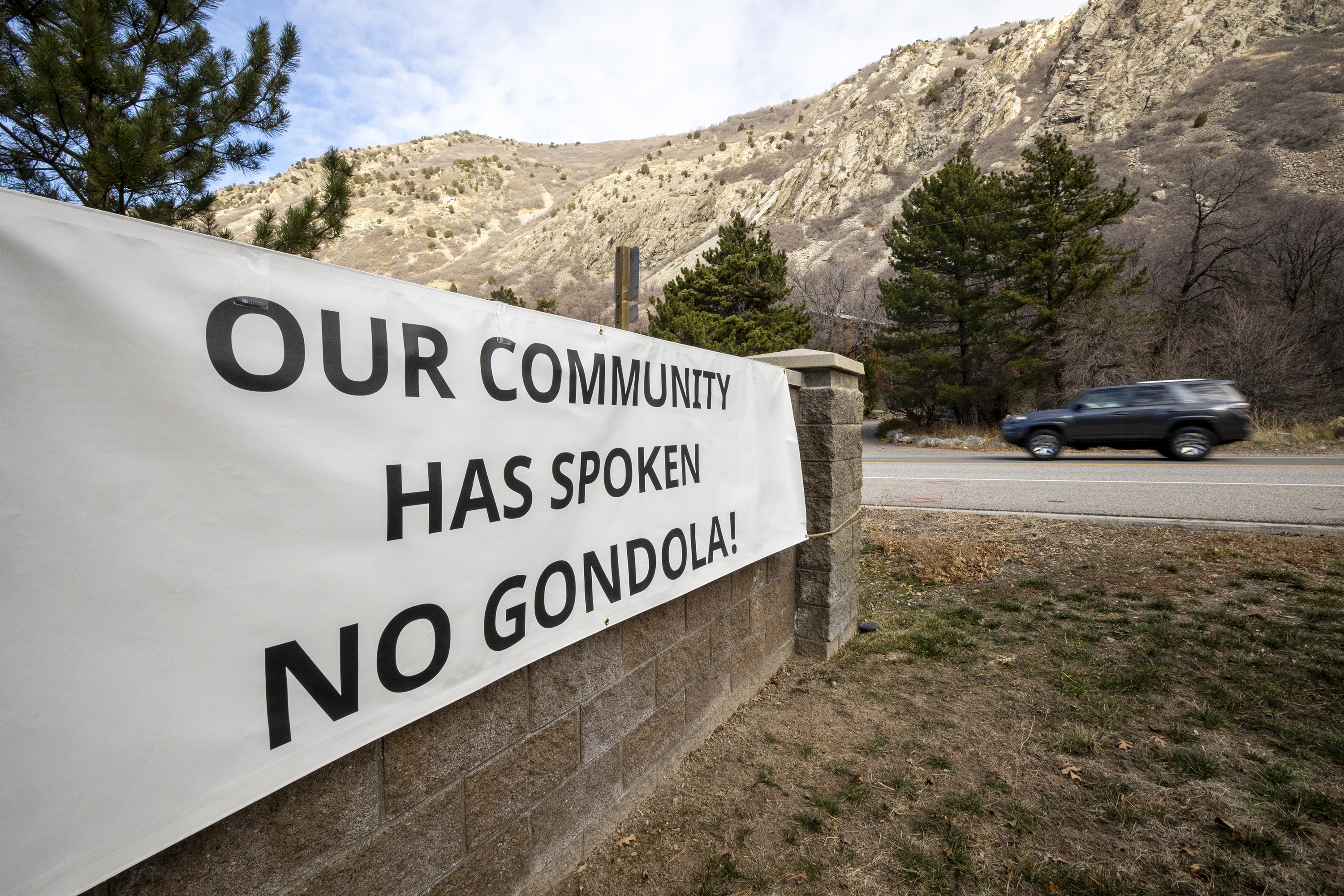 A sign opposed to a gondola is pictured near the mouth of Little Cottonwood Canyon in Cottonwood Heights on Dec. 7, 2021. The Utah Department of Transportation is currently weighing the feasibility of two options to reduce traffic in the canyon: an 8-mile gondola that would take the public to Snowbird or Alta, or an enhanced bus system with a widened road.