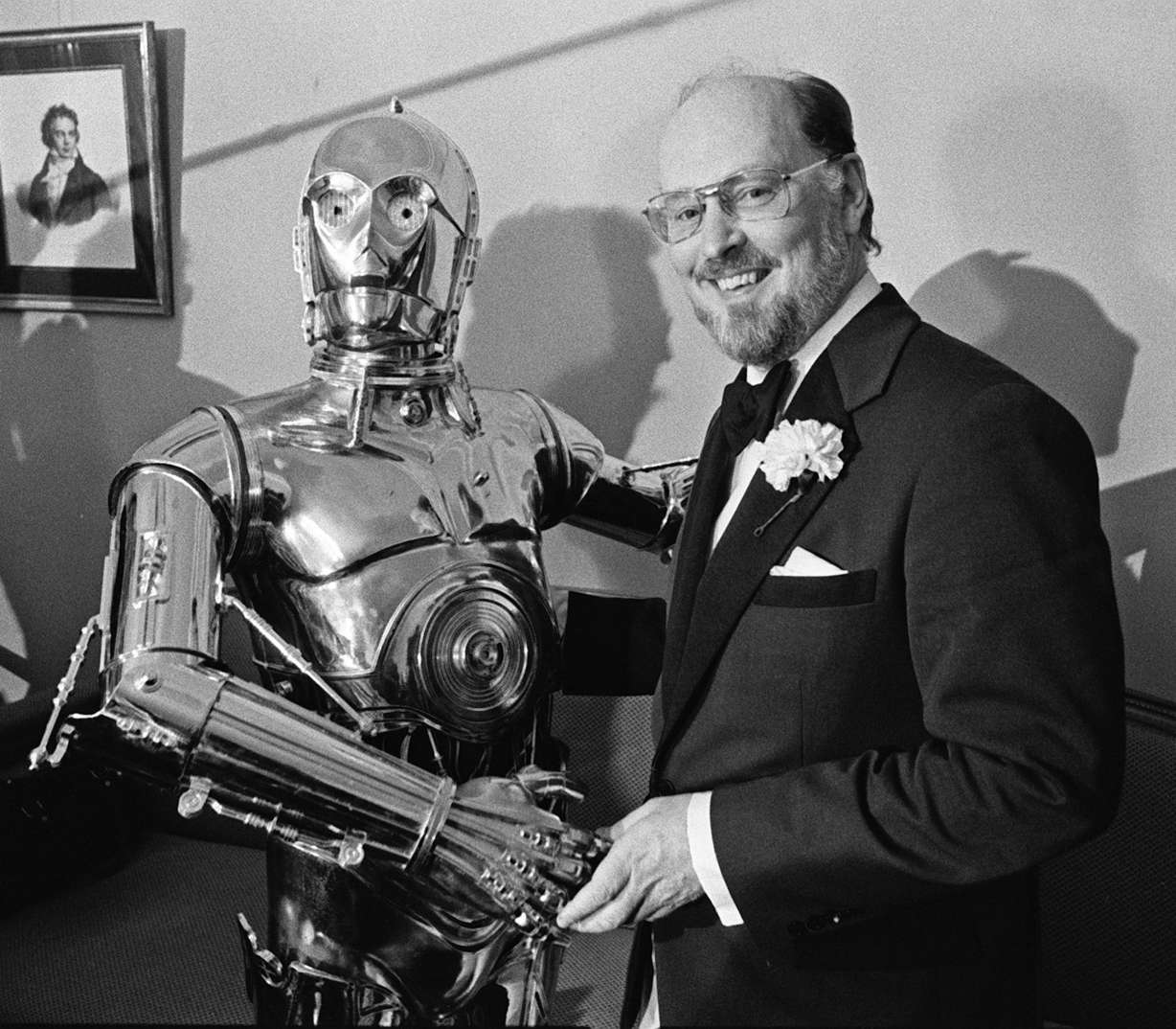 John Williams, right, shakes hands with "Star Wars" character C-3PO at a news conference in Boston on April 30, 1980.